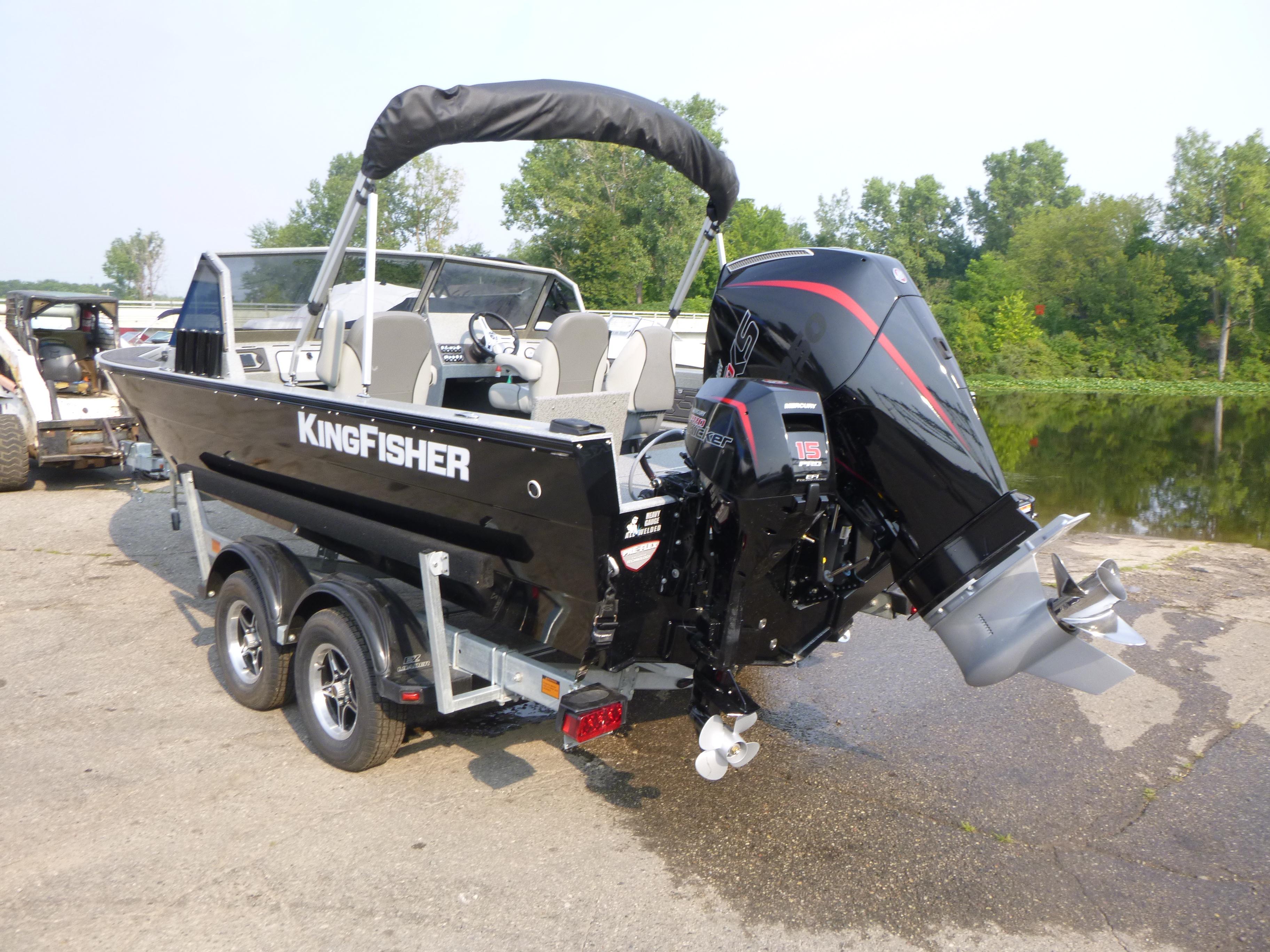2025 KingFisher 2125 Arrow Sport boat on trailer, parked near a lake.