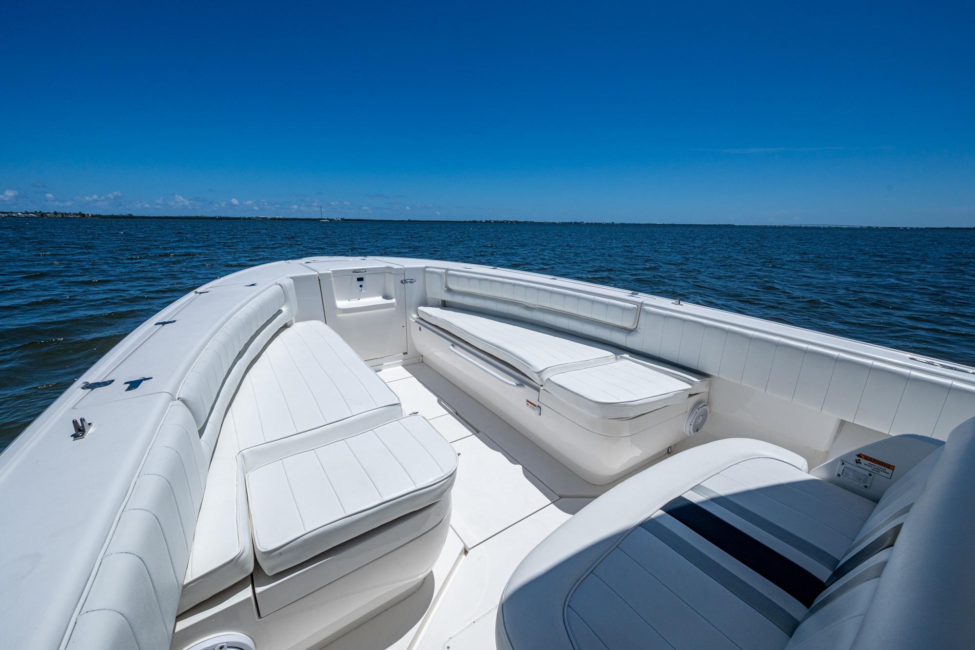 2010 Intrepid 323 OPEN boat interior with white seating, on calm blue water.