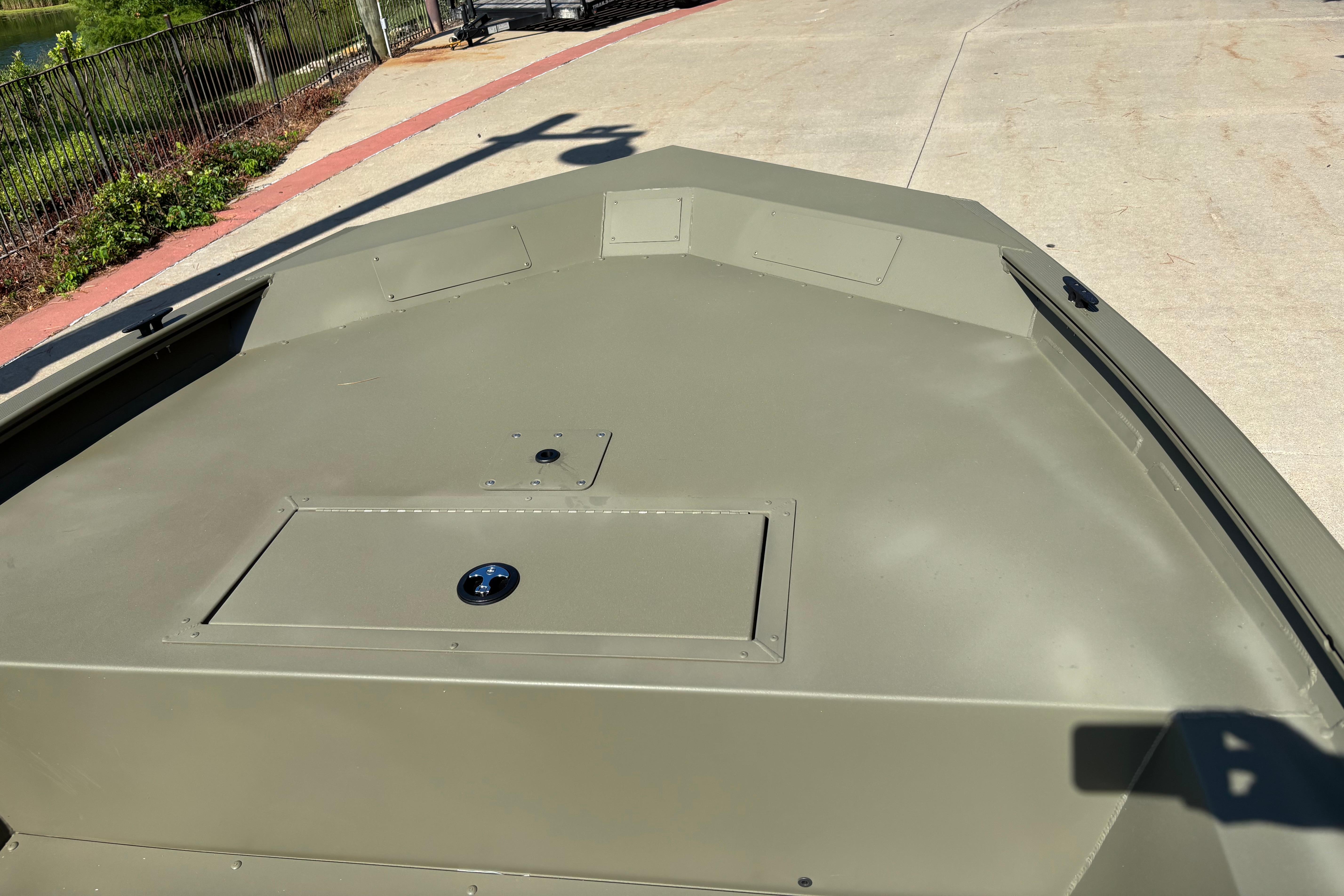 2026 Tracker Grizzly 1754 Utility boat deck, olive green, parked on concrete.