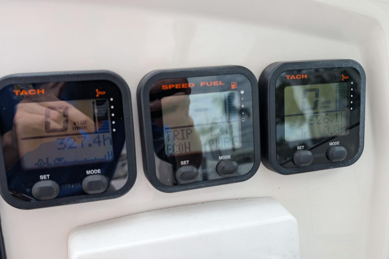 Digital gauges on a 2014 Sailfish 275 DC boat dashboard displaying tachometer and fuel information.