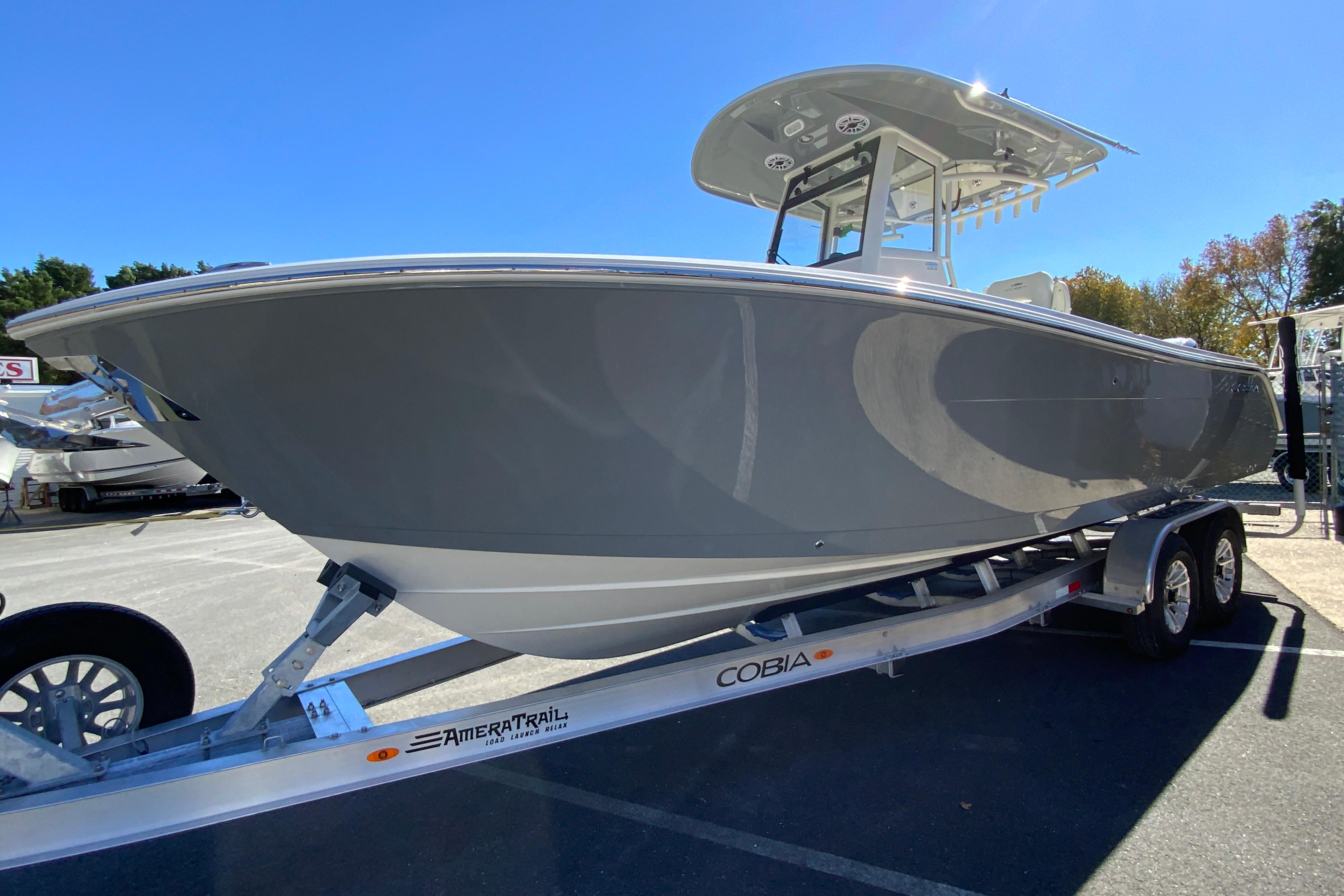 2026 Cobia 265 Center Console boat on trailer under clear blue sky.