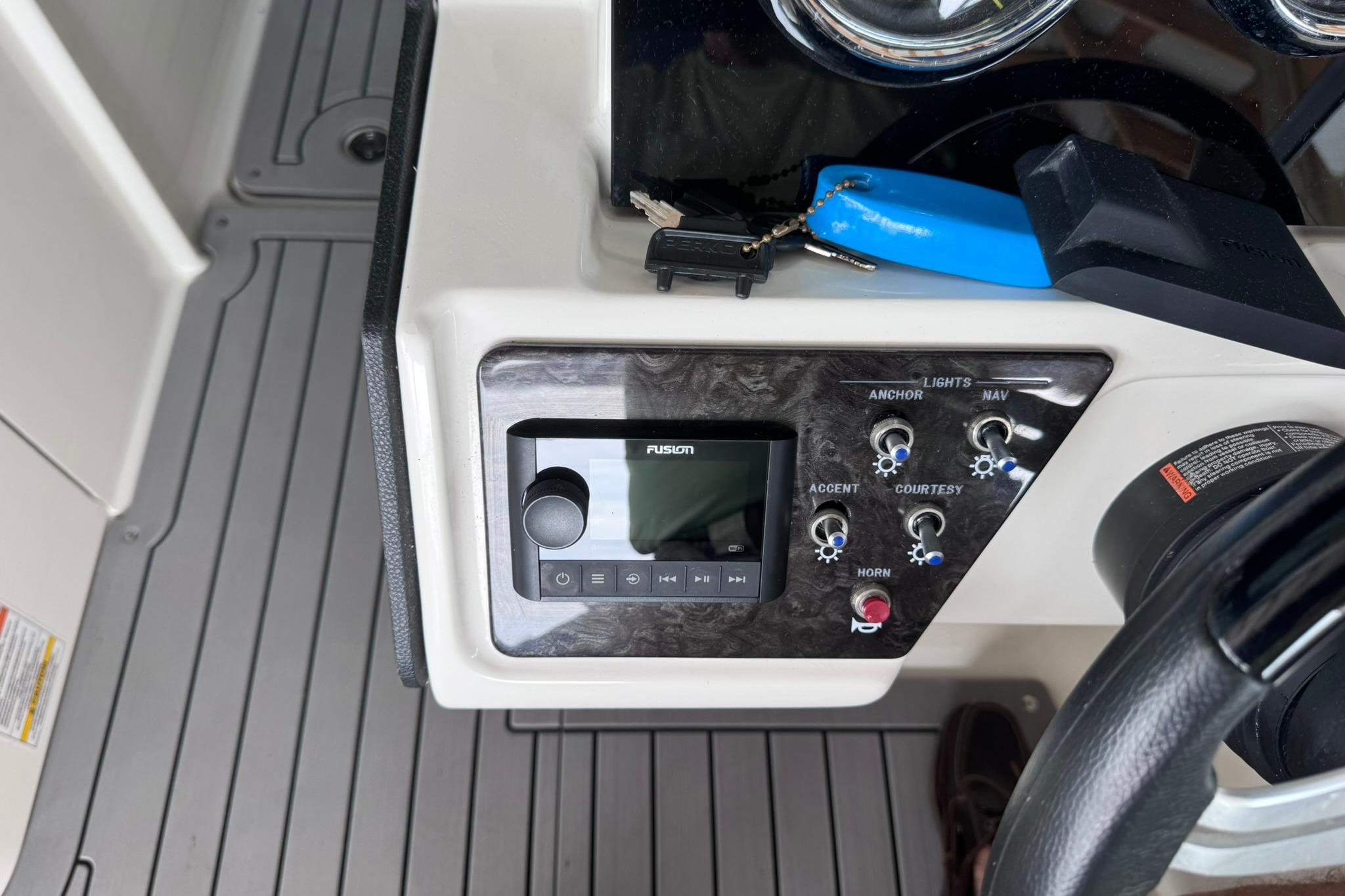 Control panel of a 2021 Sea Ray SPX 230 boat with audio system and switches.