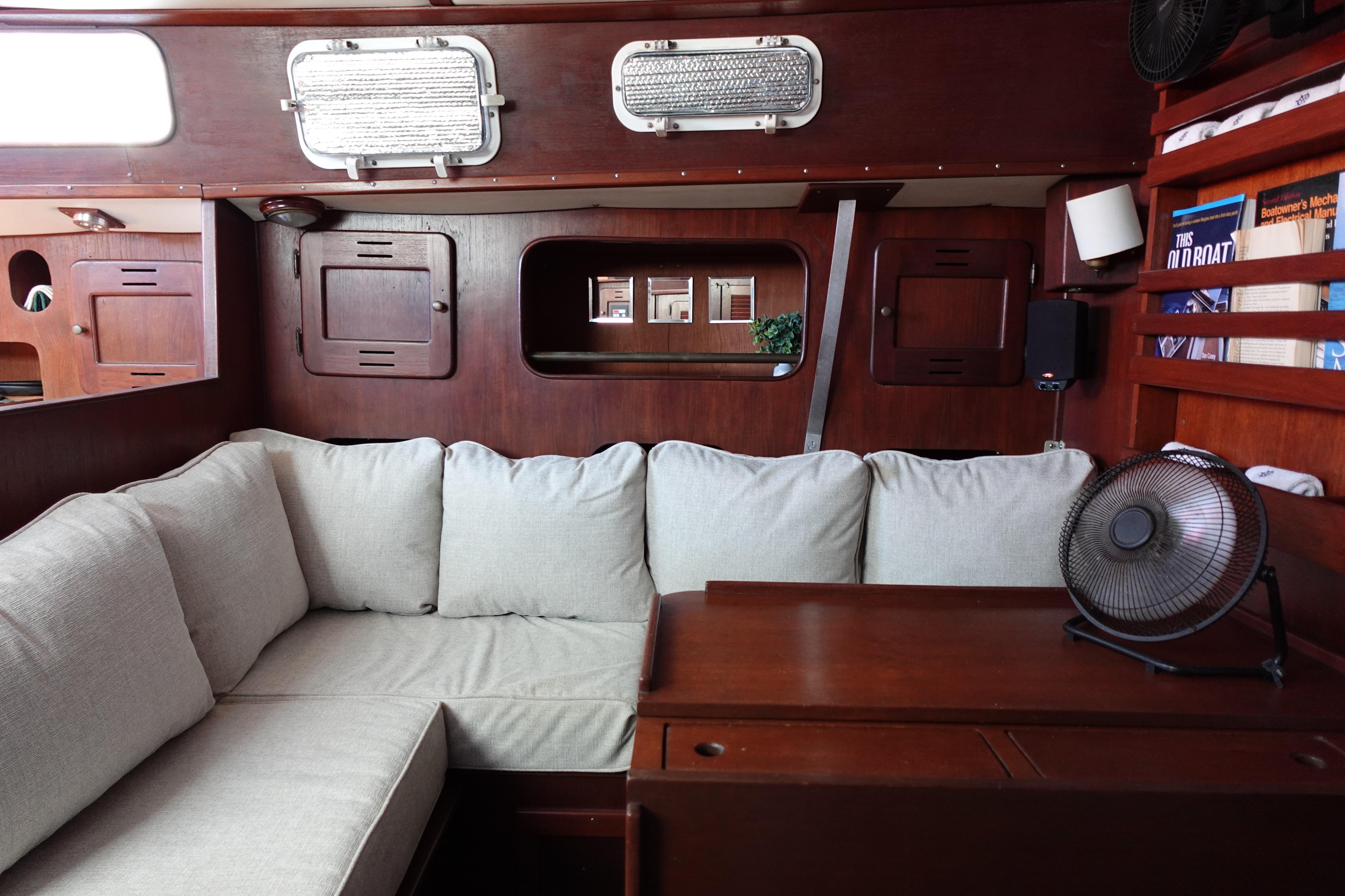 Interior of 1978 Morgan 382 sailboat with cozy seating and wooden cabinetry.