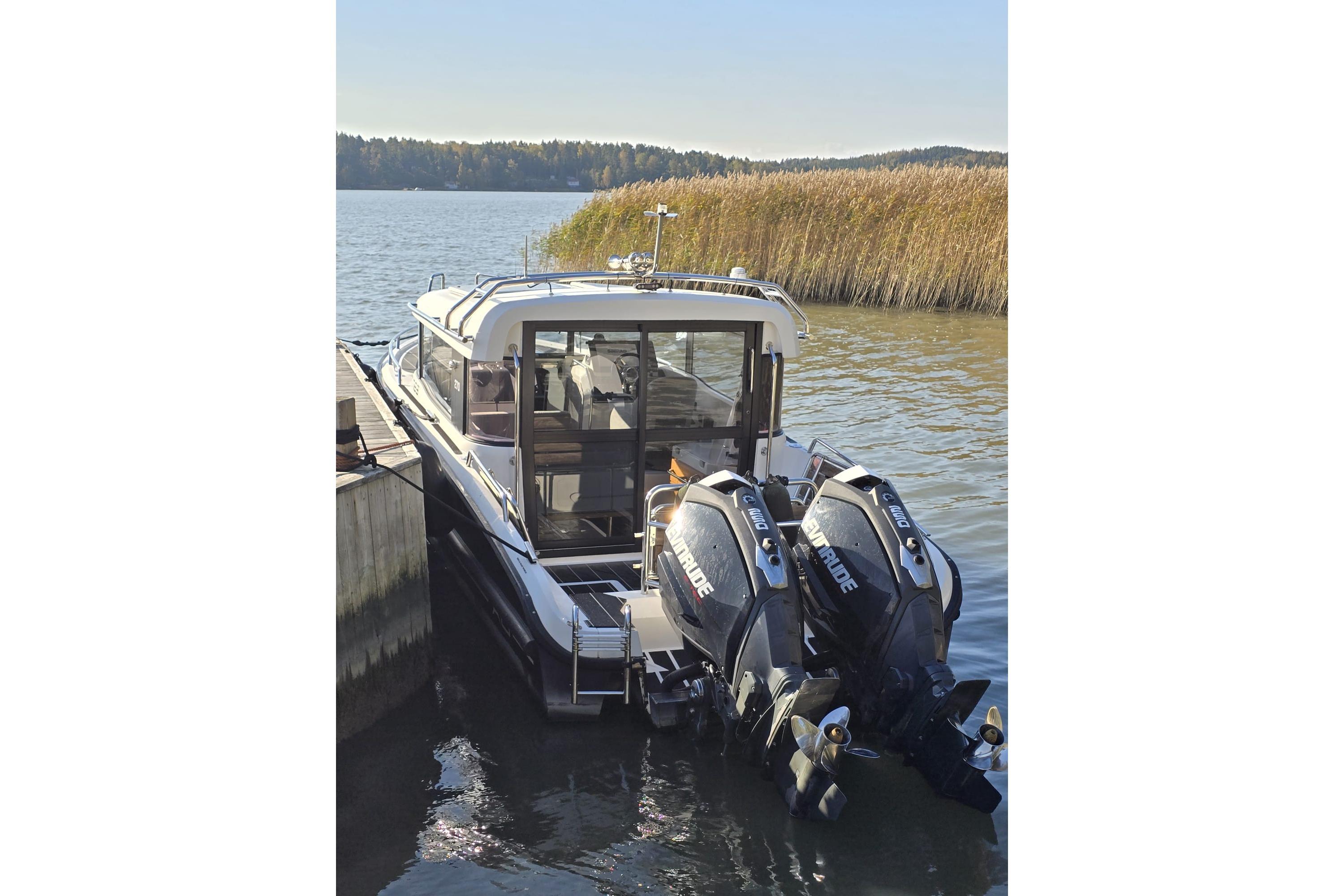 2016 XO Boats 270 RS docked with dual outboard engines on a serene lake.