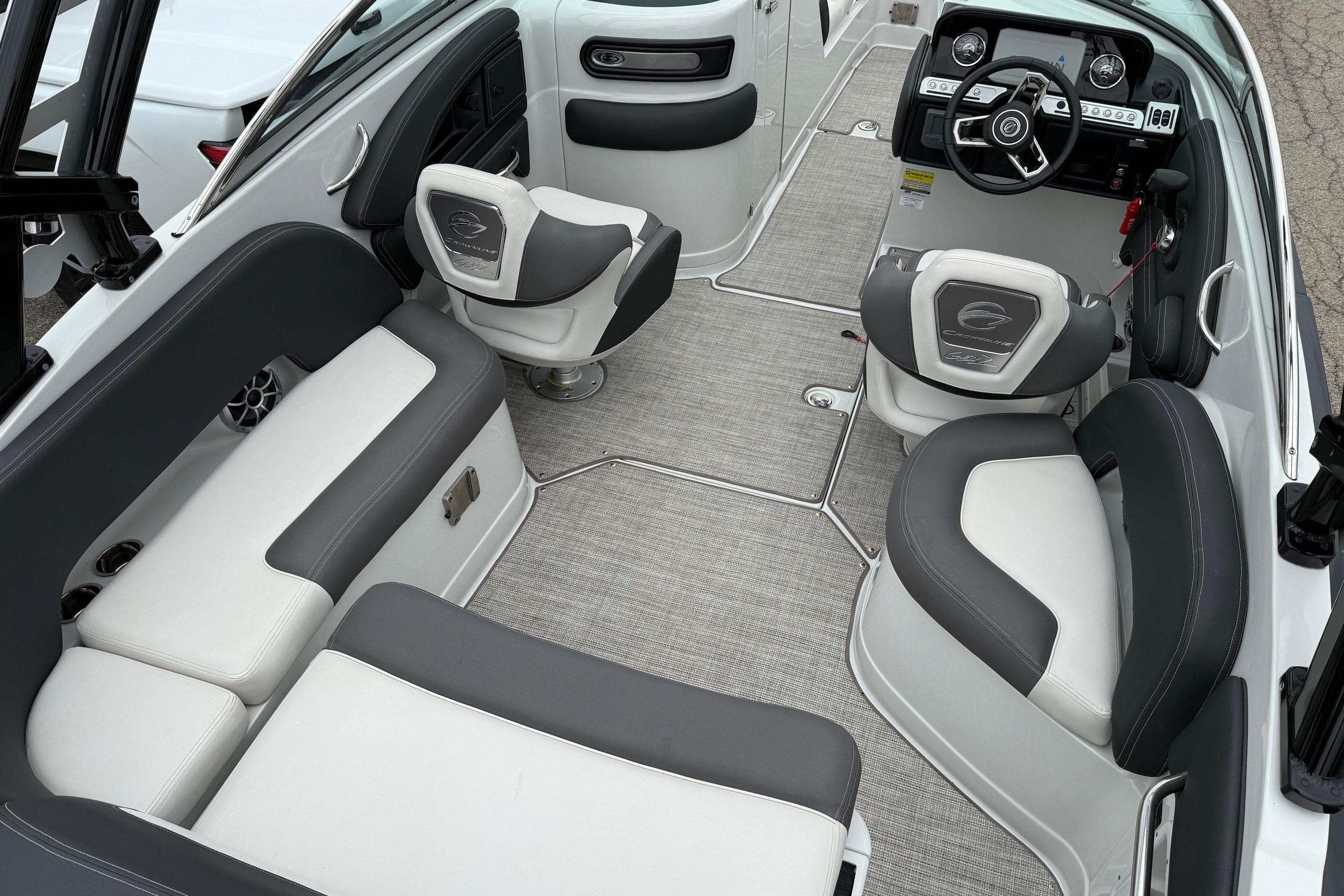 2022 Crownline 255 SS boat interior with gray and white seating, modern dashboard, and carpeted flooring.
