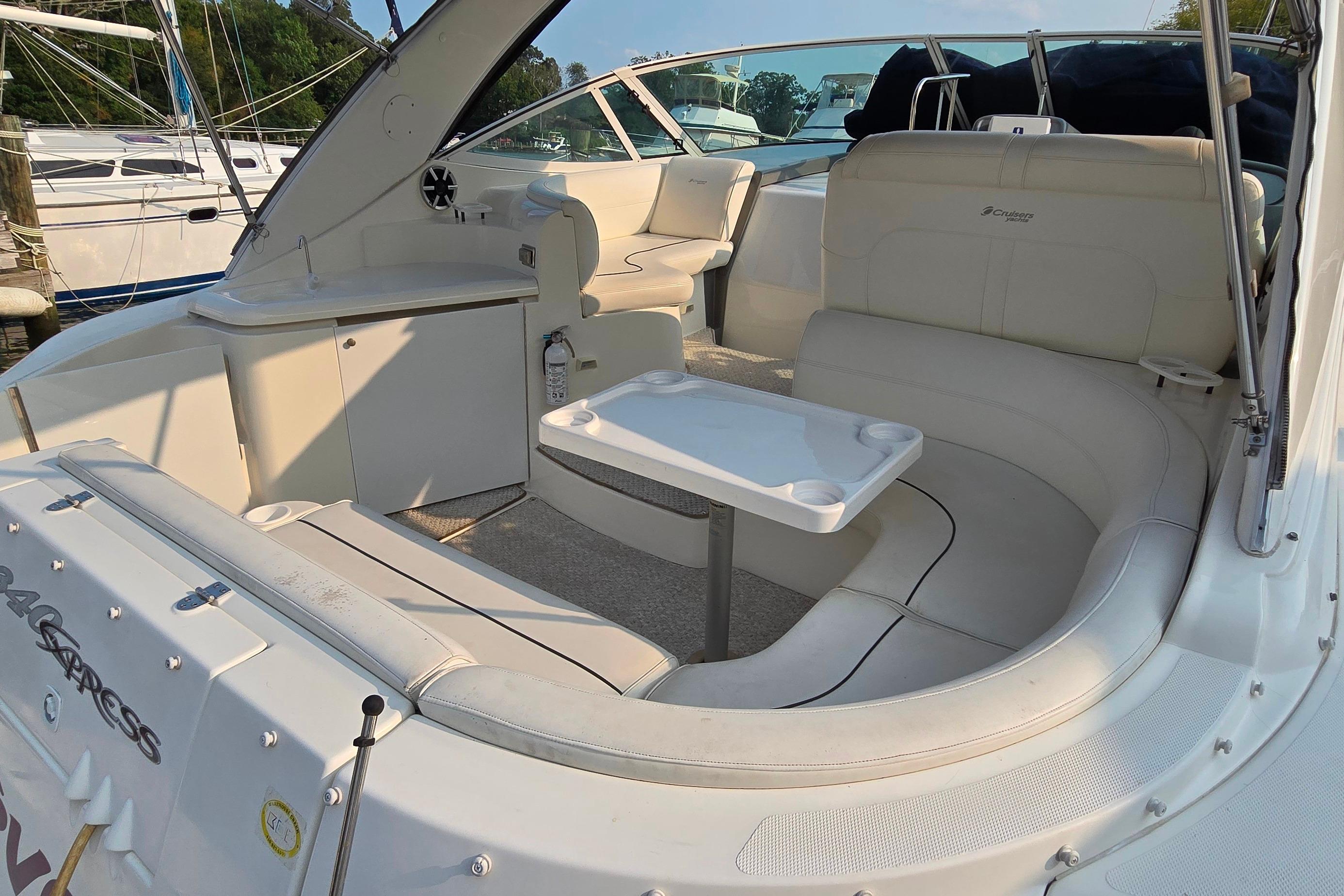 2005 Cruisers Yachts 340 Express interior with white seating and table, docked at marina.