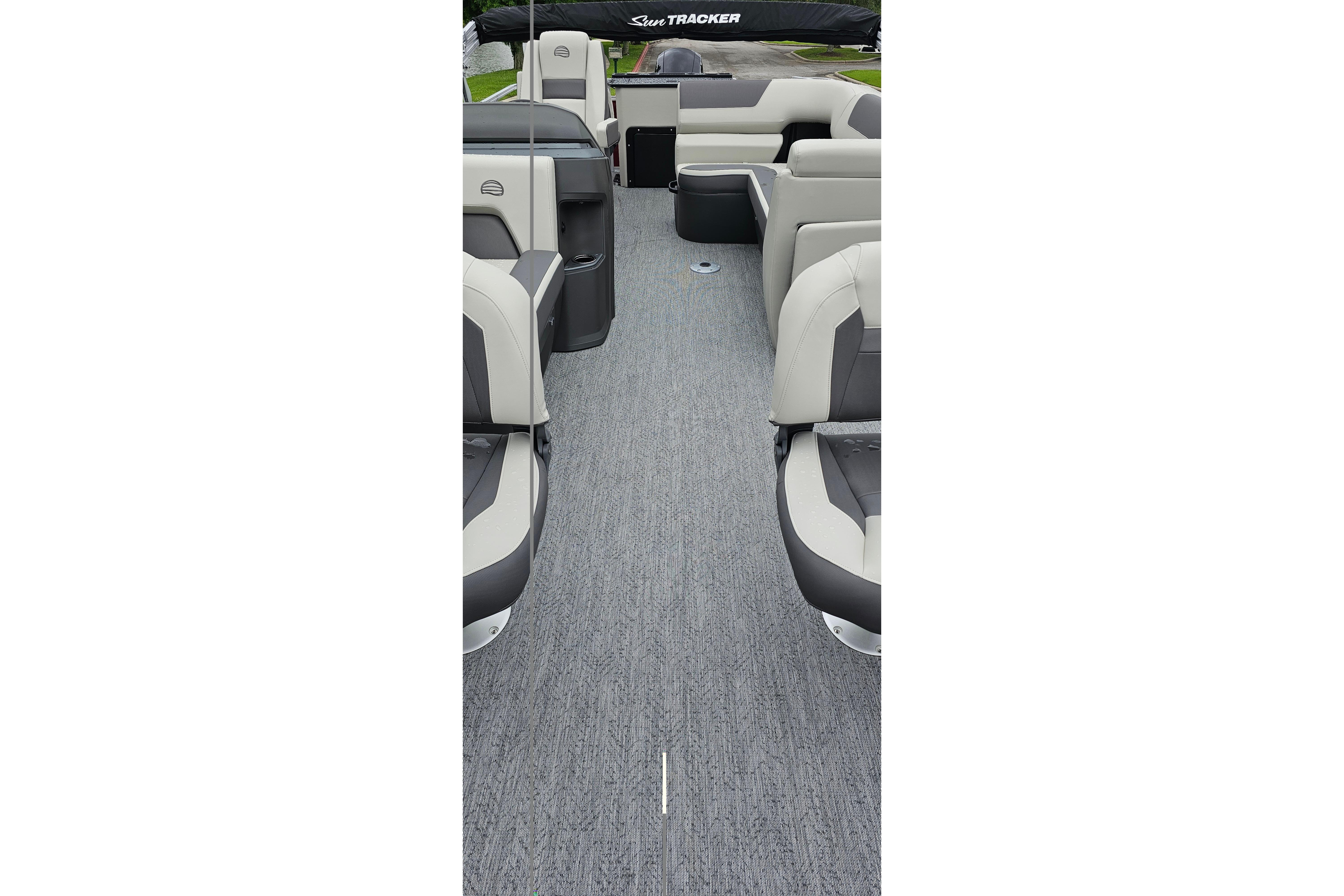 2026 Sun Tracker Fishin' Barge 22 DLX interior with gray carpet and cushioned seating.