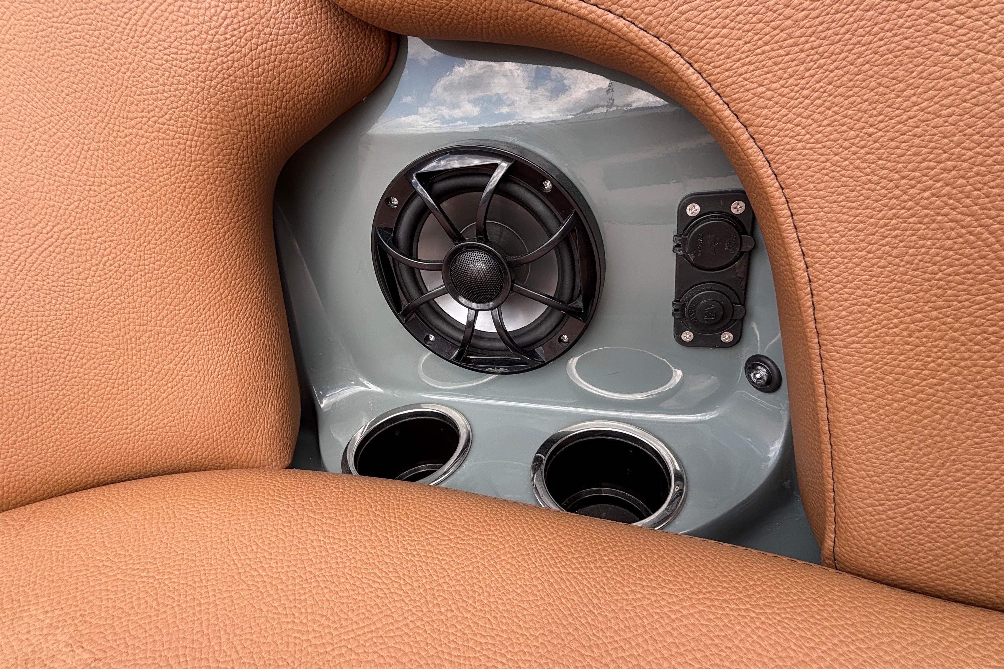 2026 MB B52 23 Classic interior detail with speaker, cup holders, and brown leather upholstery.