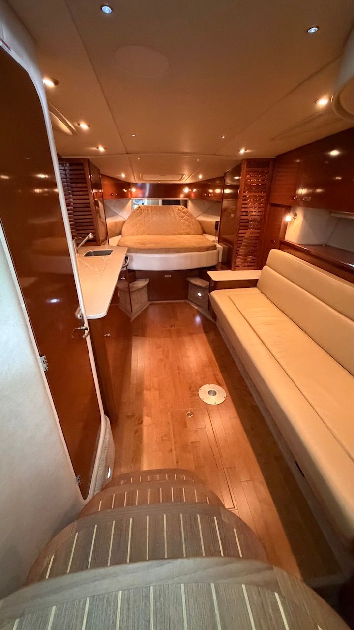 Interior of the 2011 Sea Ray Sundancer 370 with wood flooring and beige sofa.