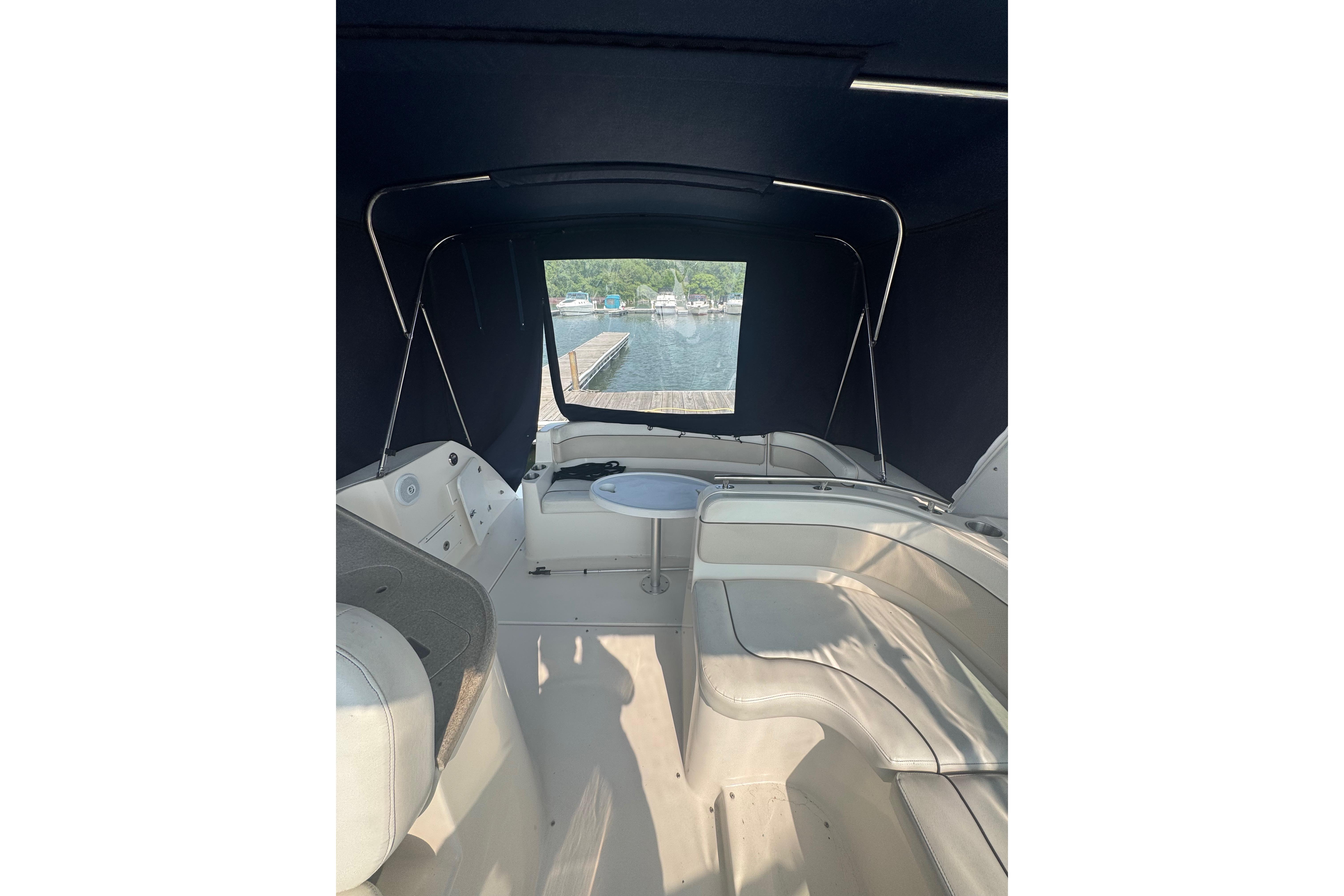 2007 Rinker 320 Express Cruiser interior with seating and table, dock view.