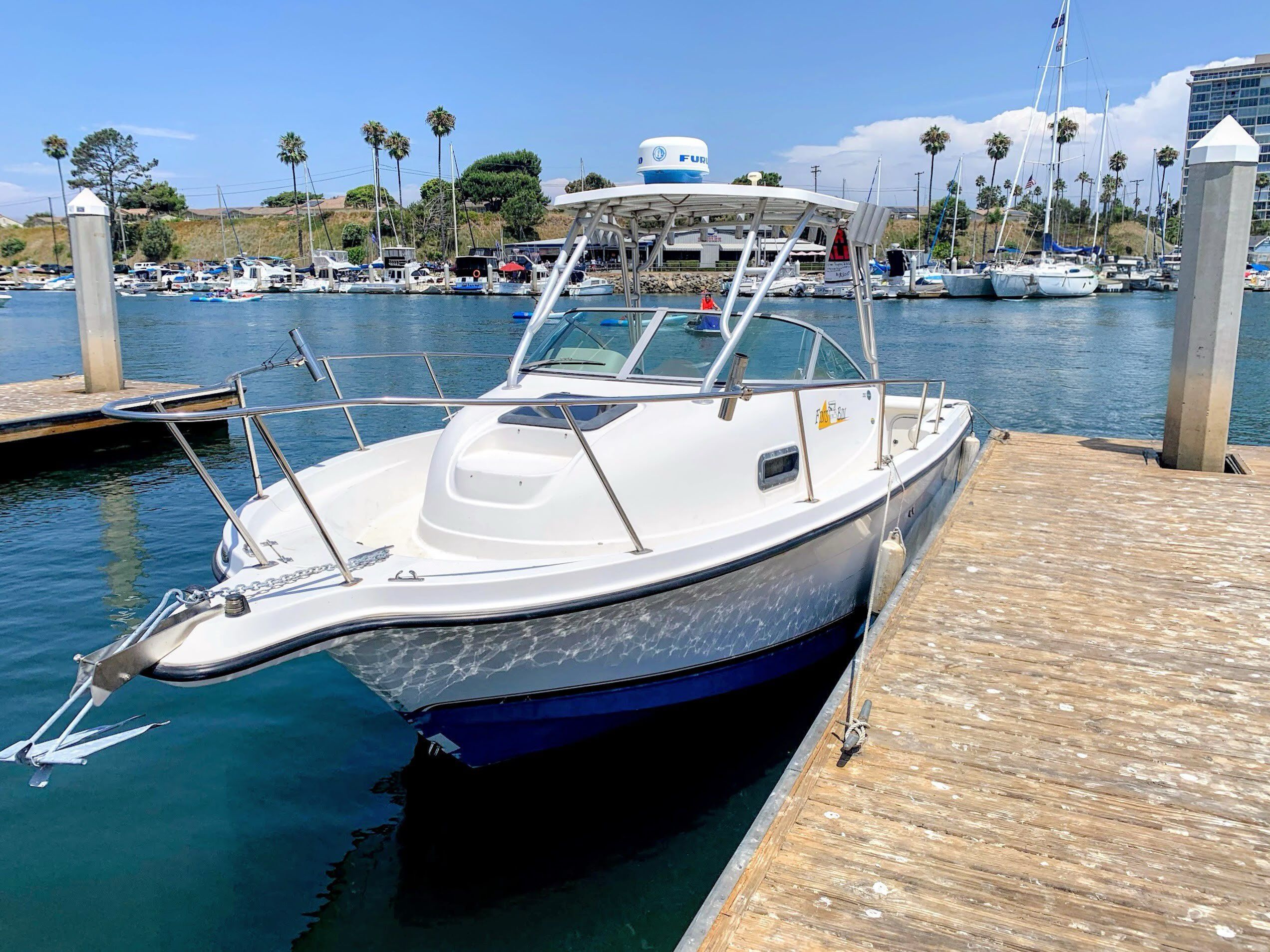 A 2003 Bayliner Walk Around Cuddy Cabin boat docked at a marina.