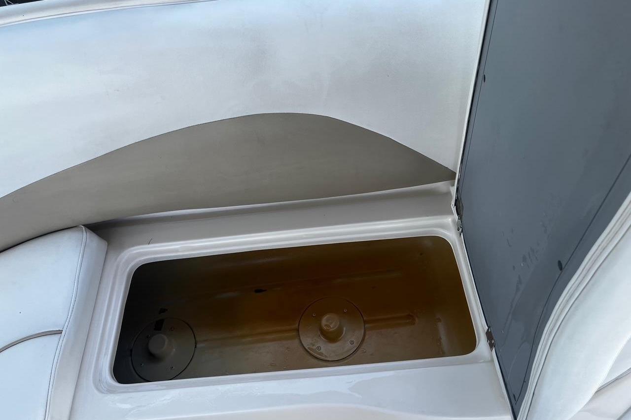 Storage compartment in a 2008 Hurricane FD202 boat, featuring a white and gray interior.