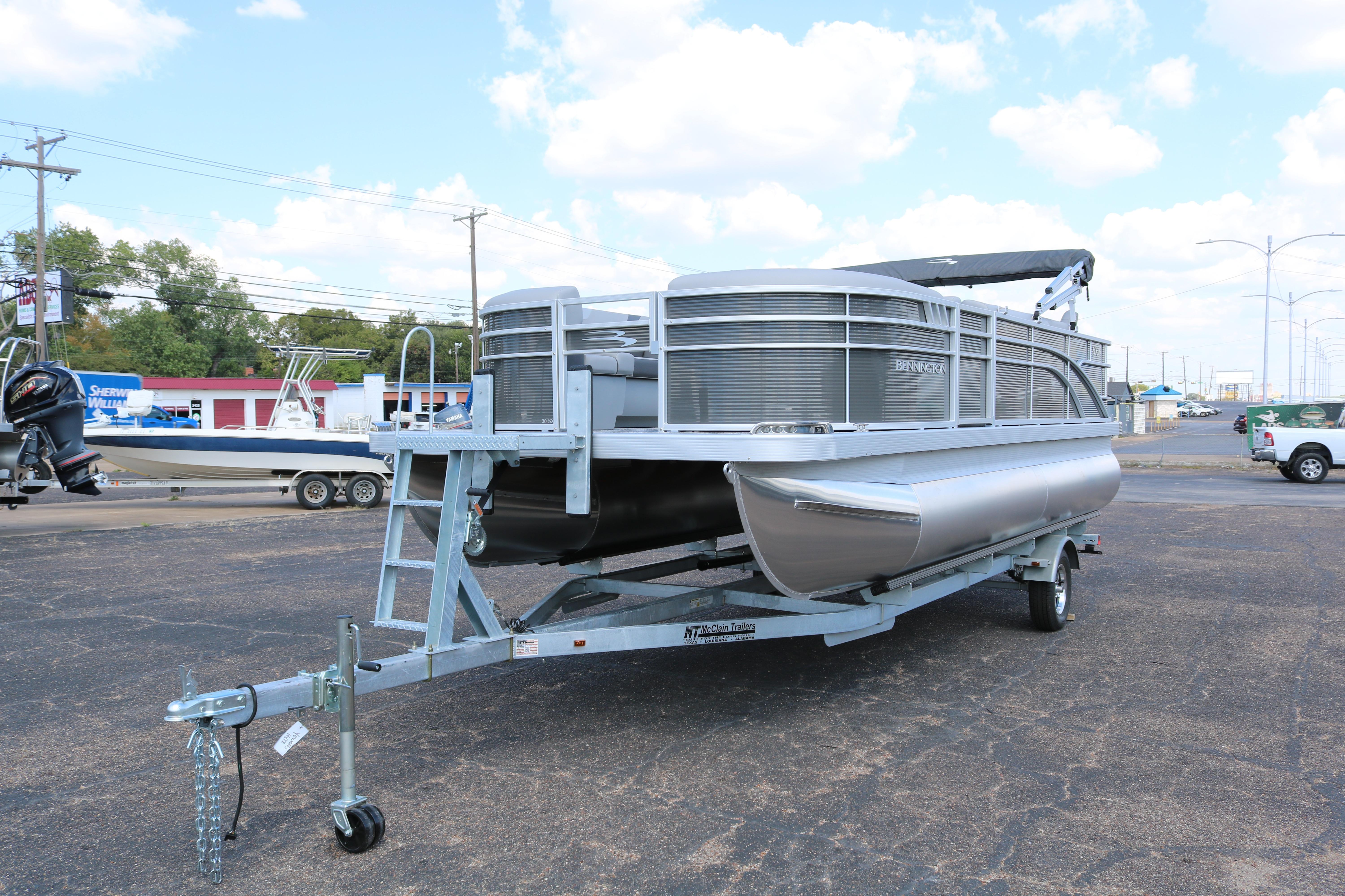 2026 Bennington 20SXSNP REAR FISH pontoon boat on a trailer in a parking lot.
