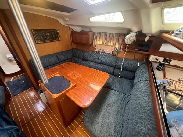 Interior of a 2000 Hunter 410 with a cozy seating area and wooden table.