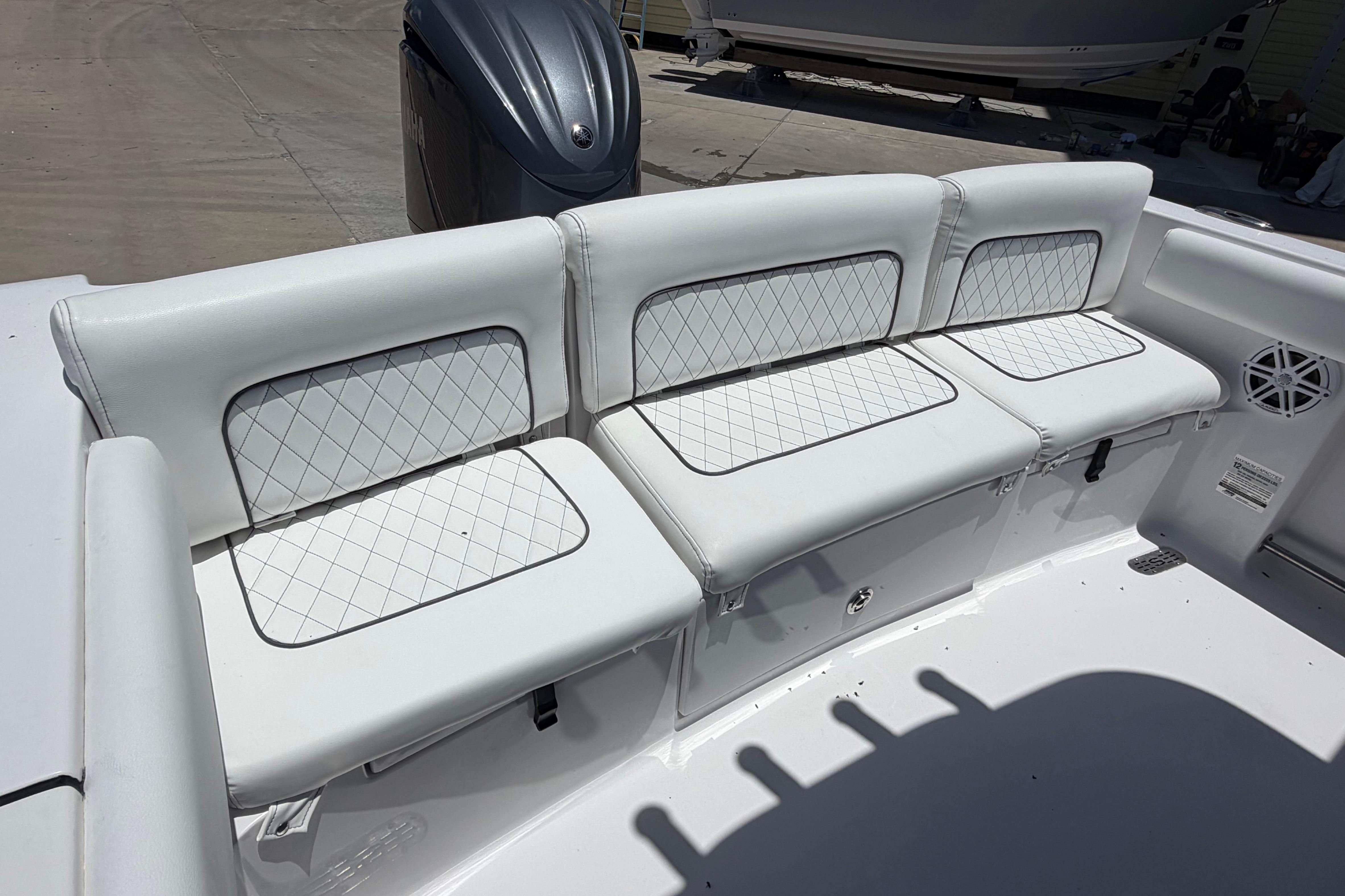 2022 Sportsman Heritage 231 Center Console boat with white cushioned seating and diamond stitching.