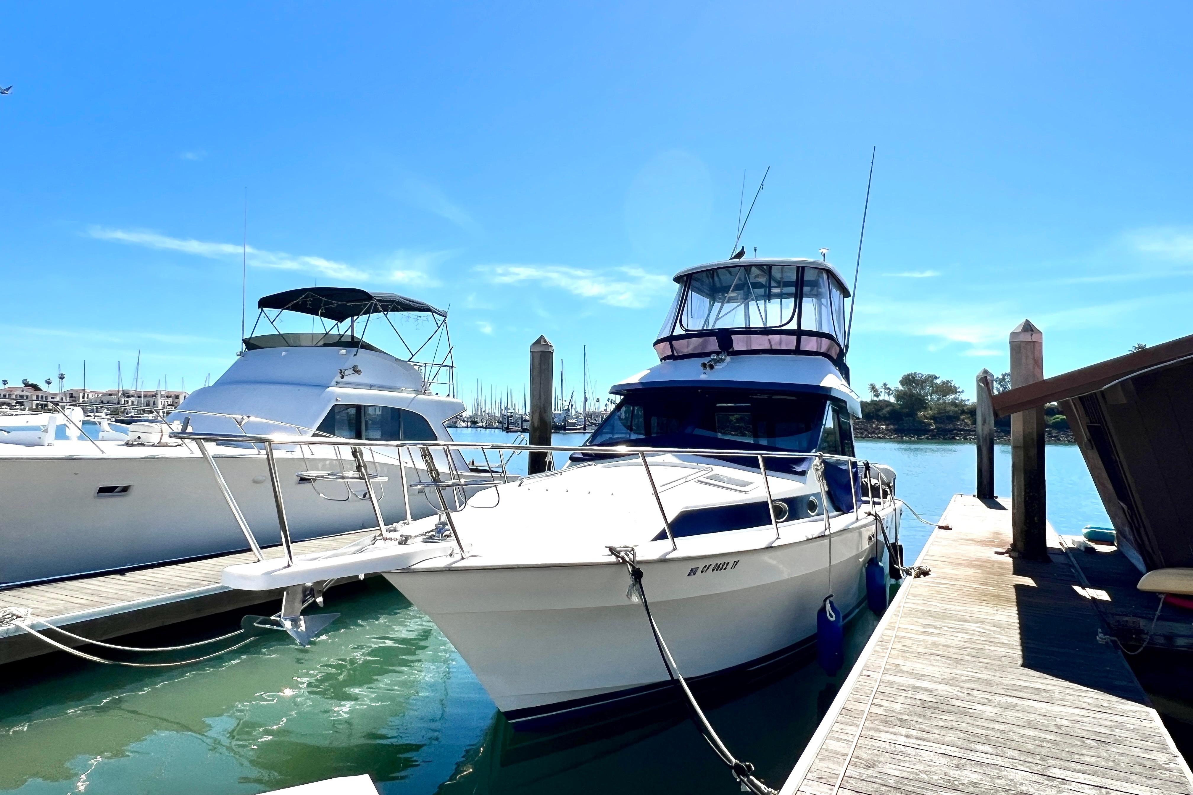 1990 Mediterranean 38 Sport Fisher docked at marina under clear blue sky.