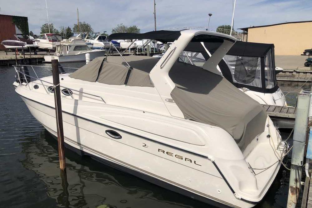 1999 Regal Commodore 2760 boat docked at marina, covered and ready for use.