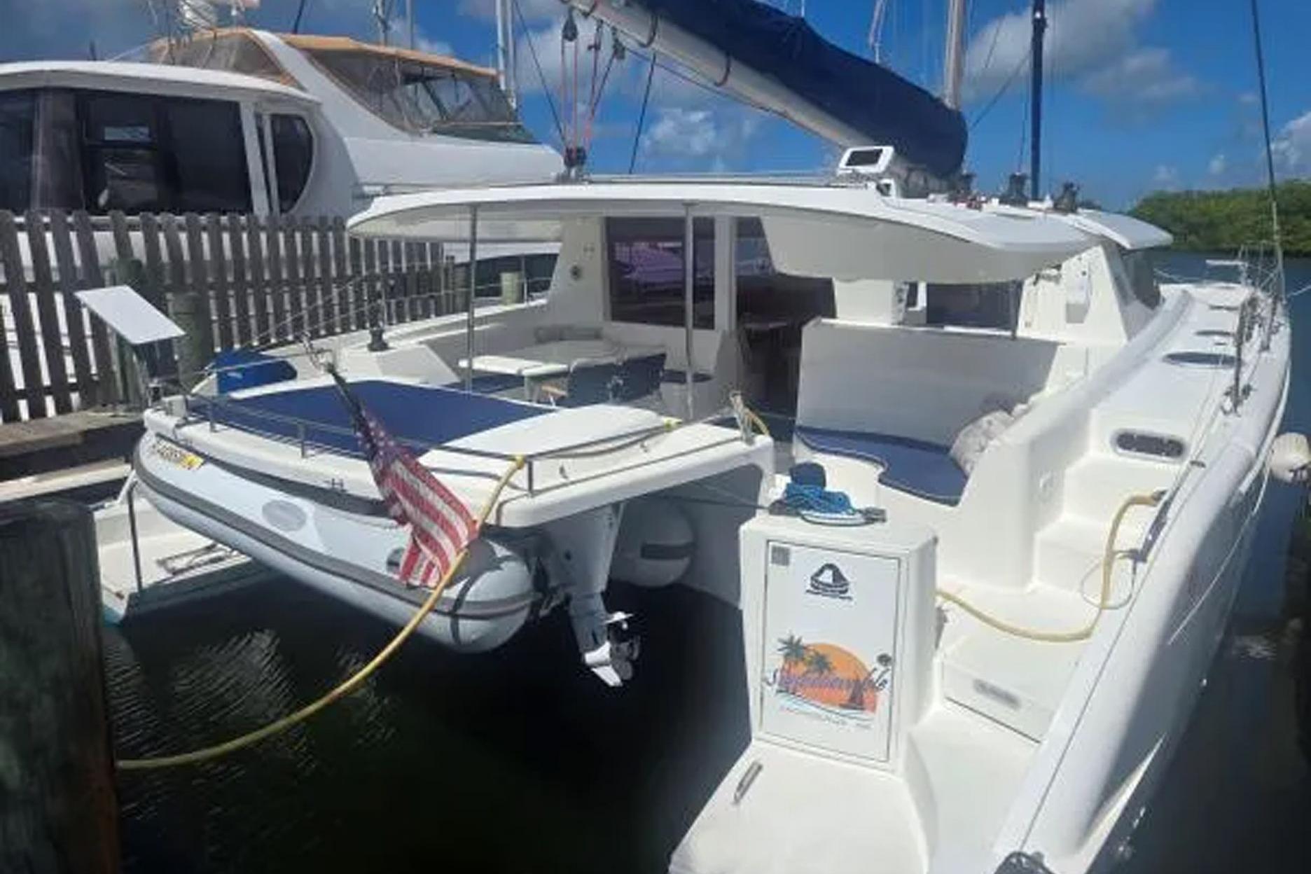 2008 Fountaine Pajot Salina 48 catamaran docked, featuring spacious deck and American flag.