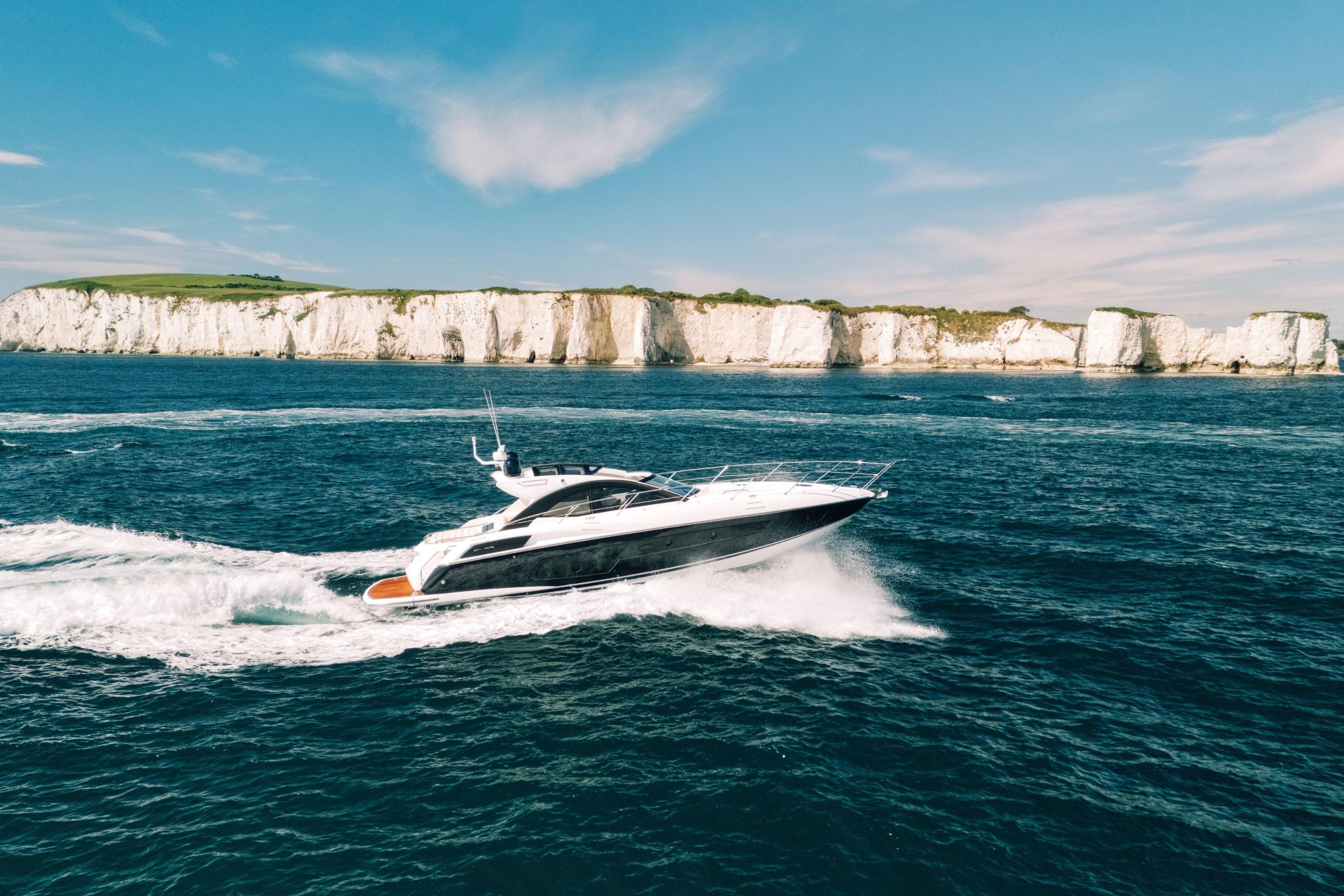 Sunseeker San Remo 485 yacht cruising near white cliffs, 2013 model.