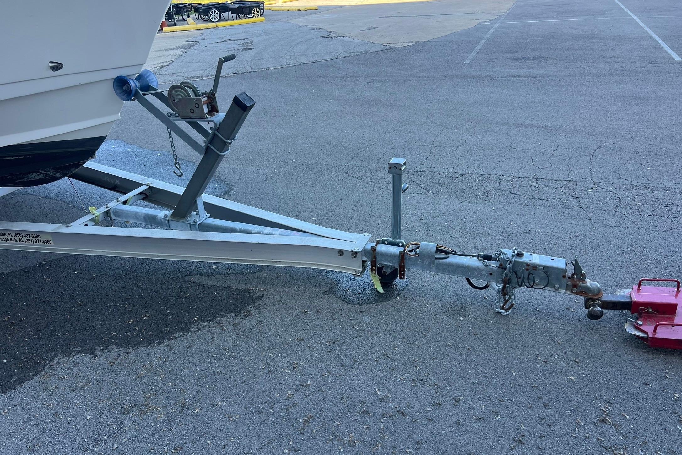 Trailer hitch of a 2006 Edgewater 245CC boat on asphalt pavement.