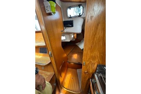 Interior view of 1986 Beneteau First 305 sailboat, featuring wooden finishes and compact design.