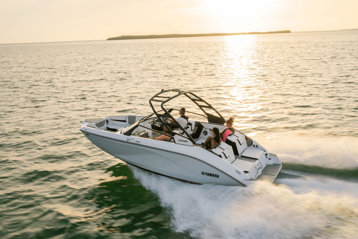 A Yamaha 222SD boat cruising on the water at sunset.