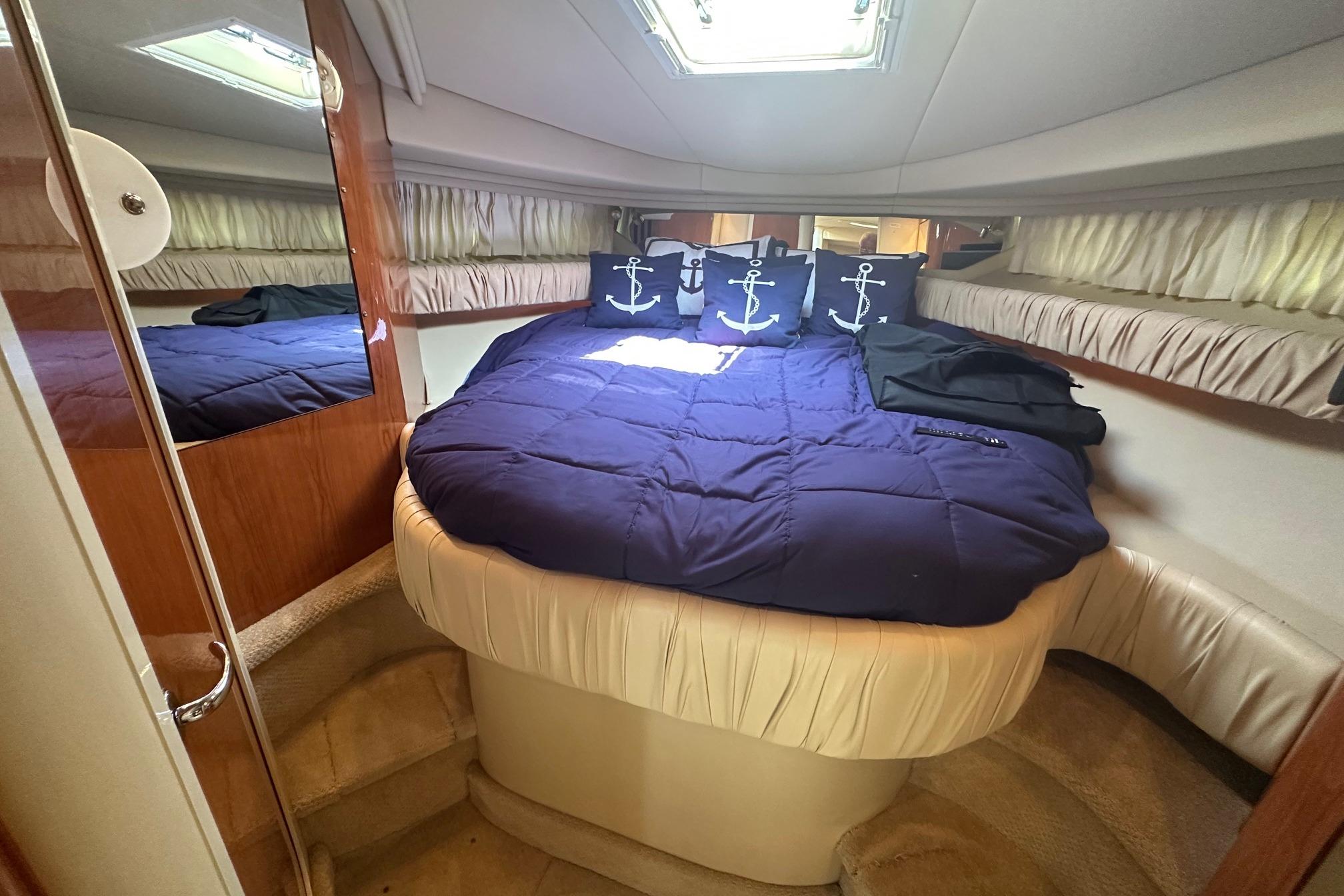 Luxurious cabin interior of 2001 Sea Ray 410 Sundancer with nautical-themed bedding.