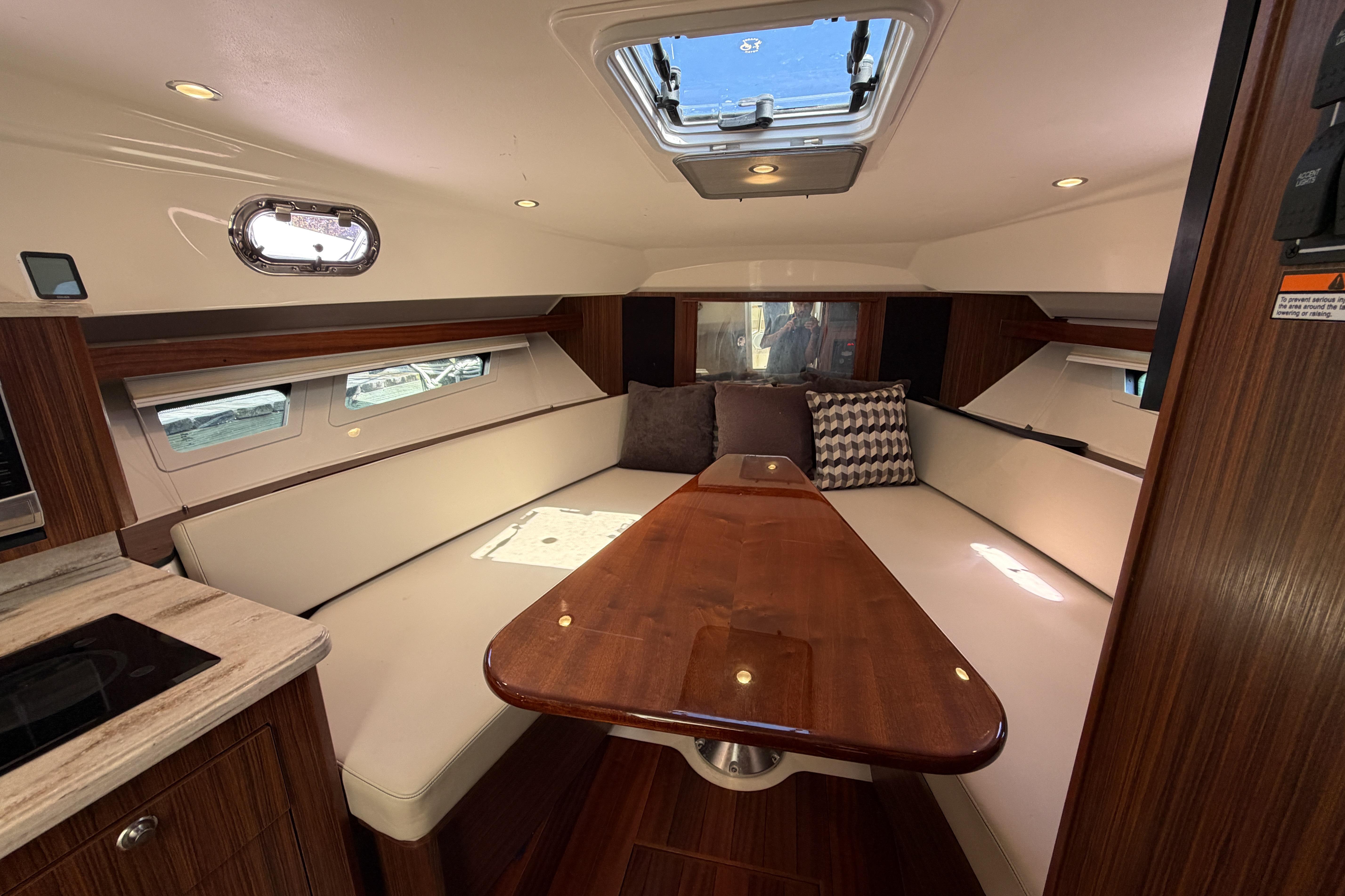 Luxurious interior of 2018 Pursuit OS 355 Offshore boat with elegant seating and wooden table.