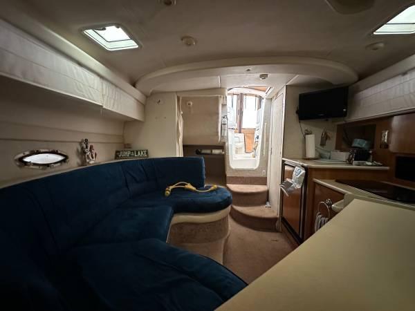 Interior of 2002 Bayliner 3055 Ciera with blue seating, kitchenette, and stairs to deck.