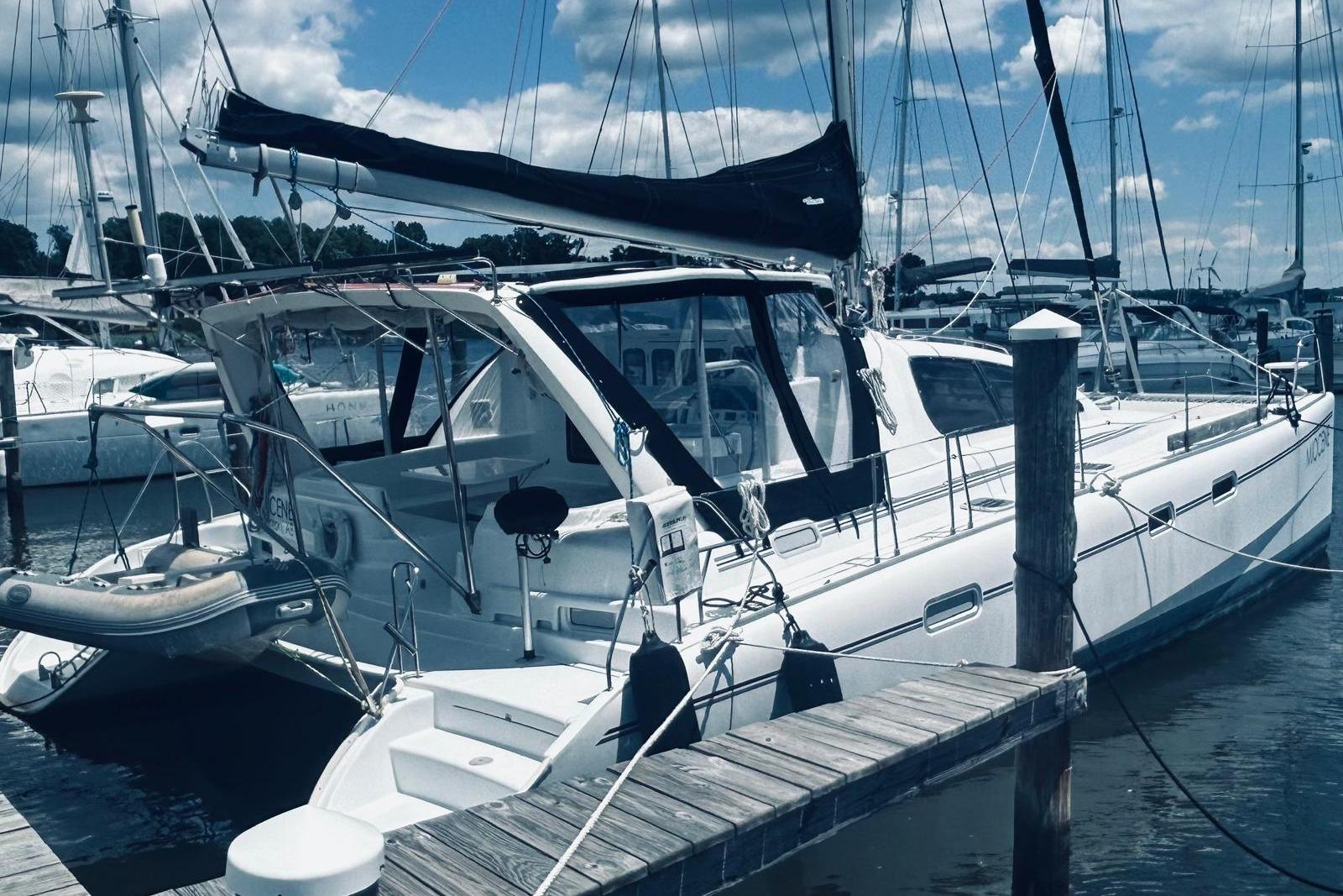 2001 Robertson & Caine Leopard yacht docked at marina under blue sky.
