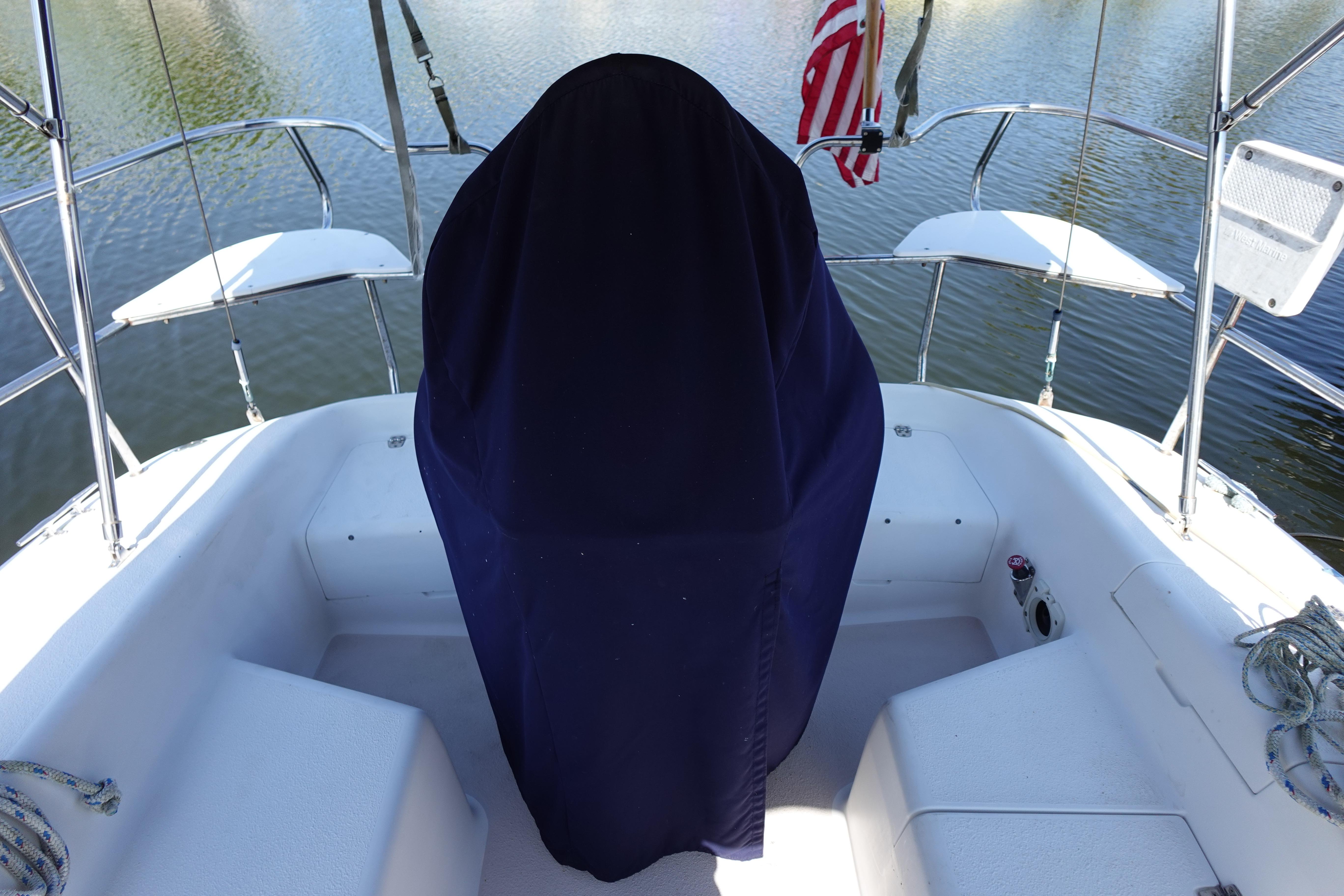 1997 Catalina 28 sailboat cockpit with covered helm, docked on calm water.