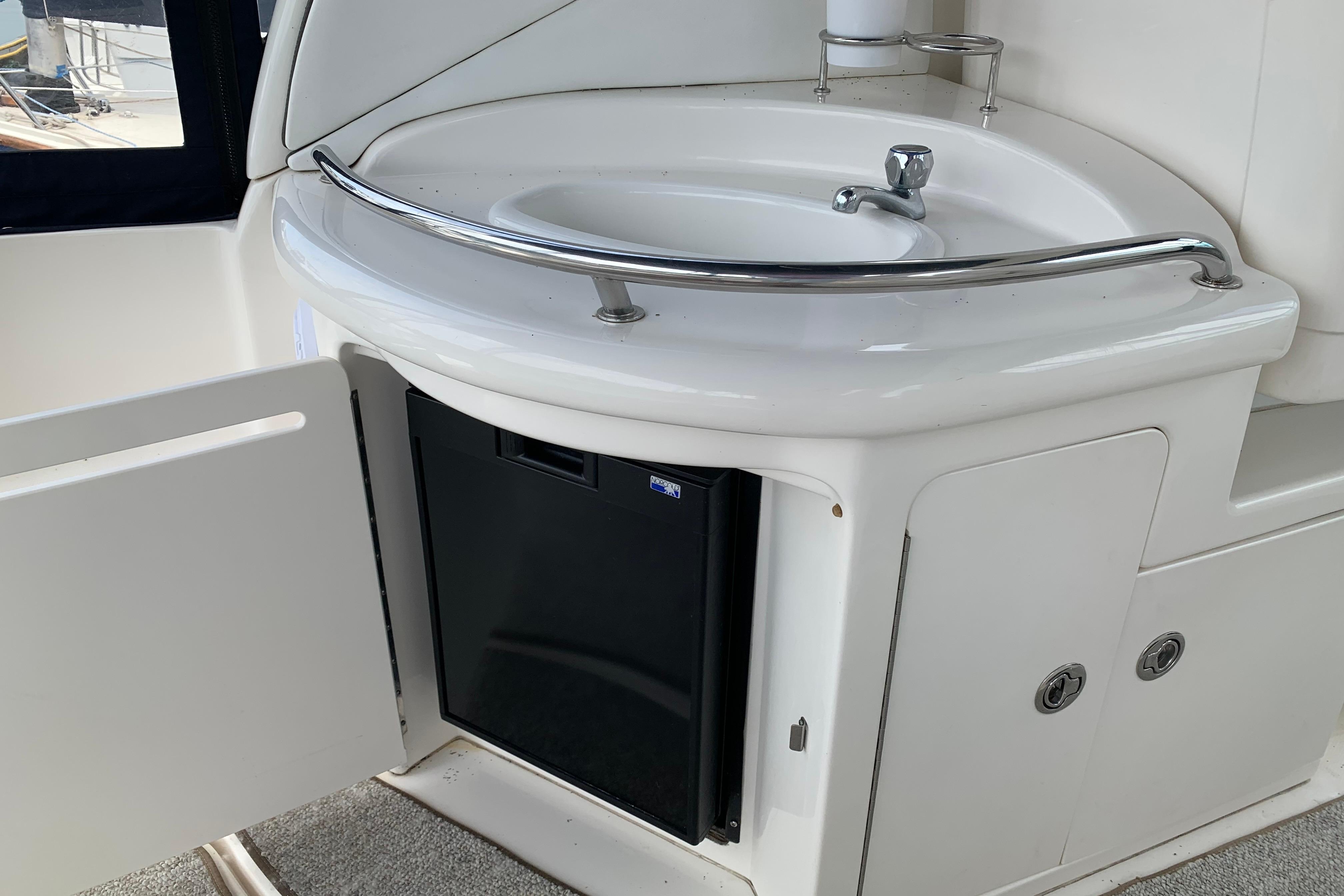 2007 Sea Ray 340 Sundancer boat sink and mini fridge in cabin area.