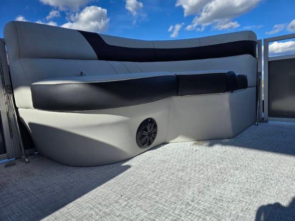 2025 Berkshire 20 CL boat interior with cushioned seating and speaker, under a blue sky.