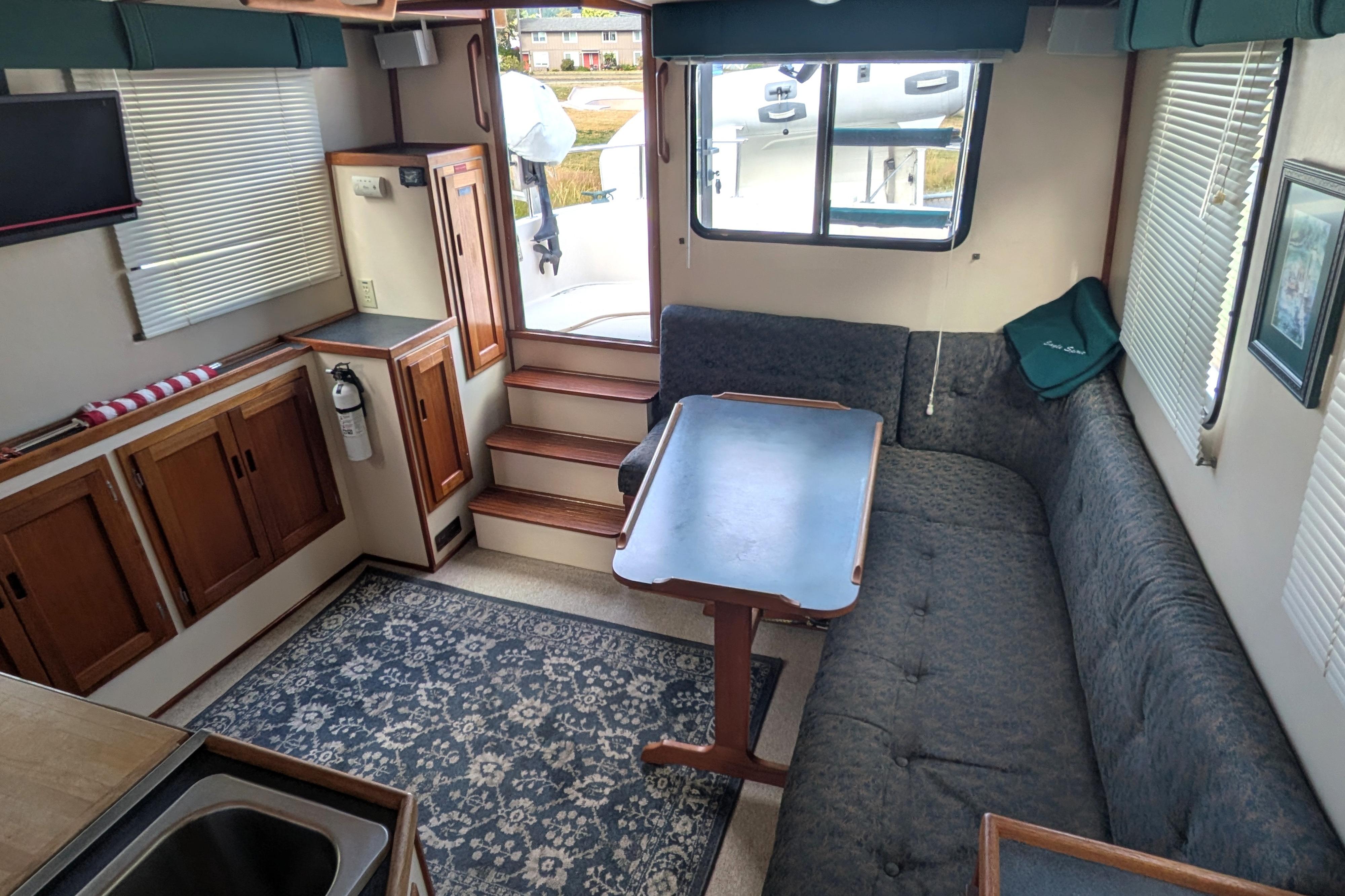 Interior of a 1998 Nordic Tug 32, featuring a cozy dining area with a wooden table.