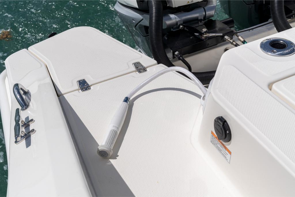 2024 Boston Whaler 280 Dauntless deck with washdown hose and engine components.