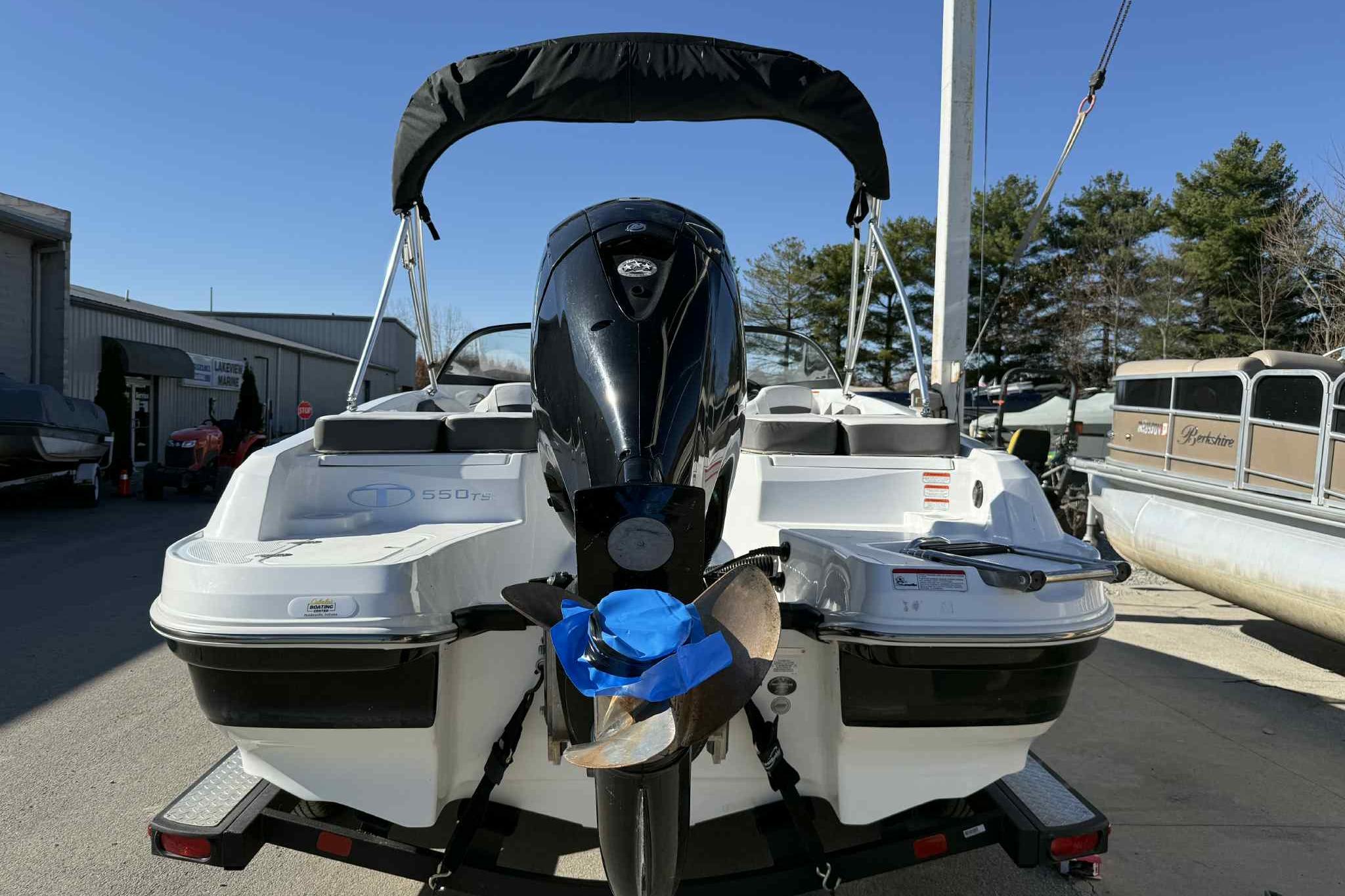 2021 Tahoe 550 TS boat with outboard motor, parked on a trailer.
