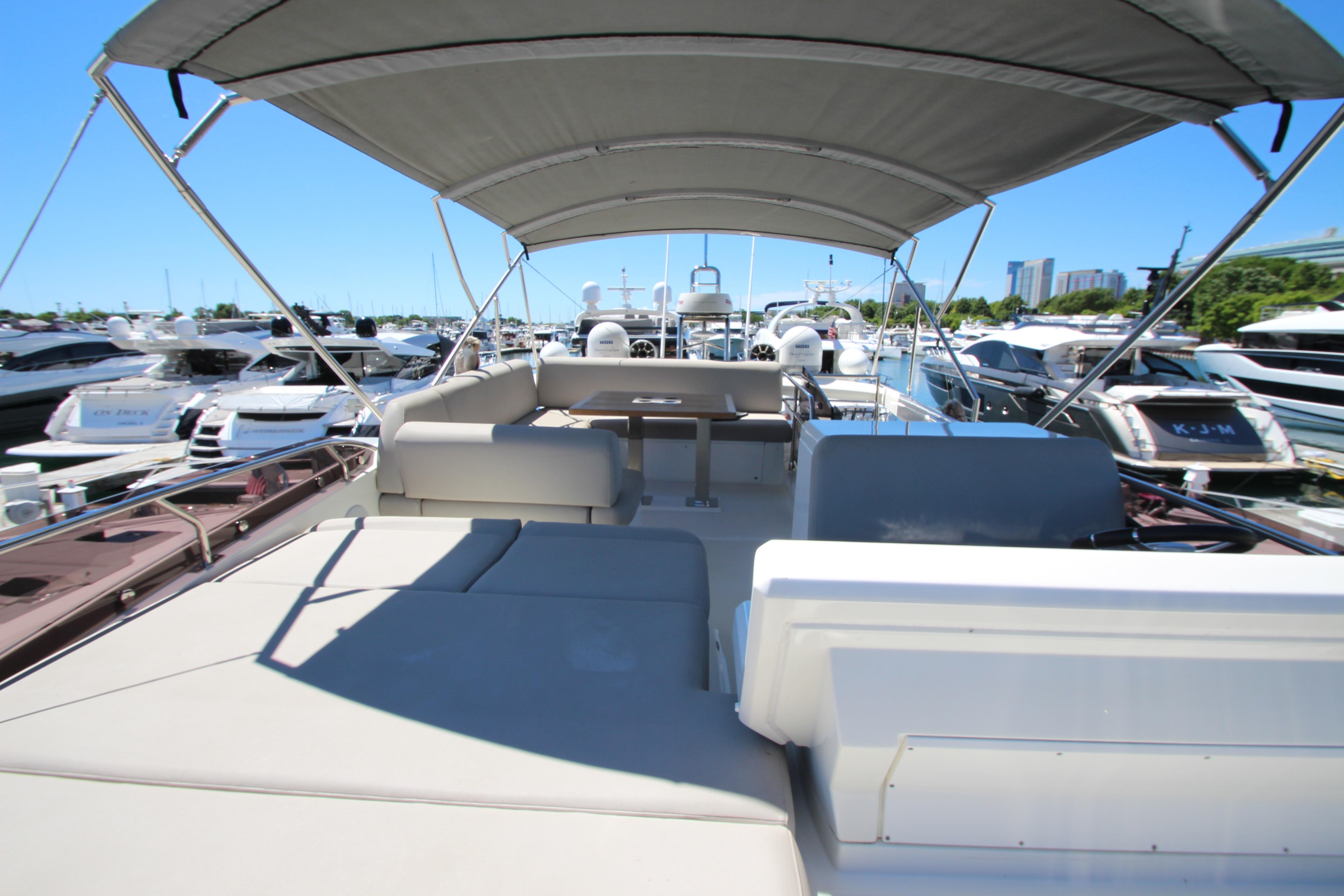 2022 Prestige 520 yacht with spacious deck and canopy in marina setting.