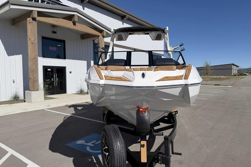 2026 Supra SL boat on trailer in parking lot, front view.