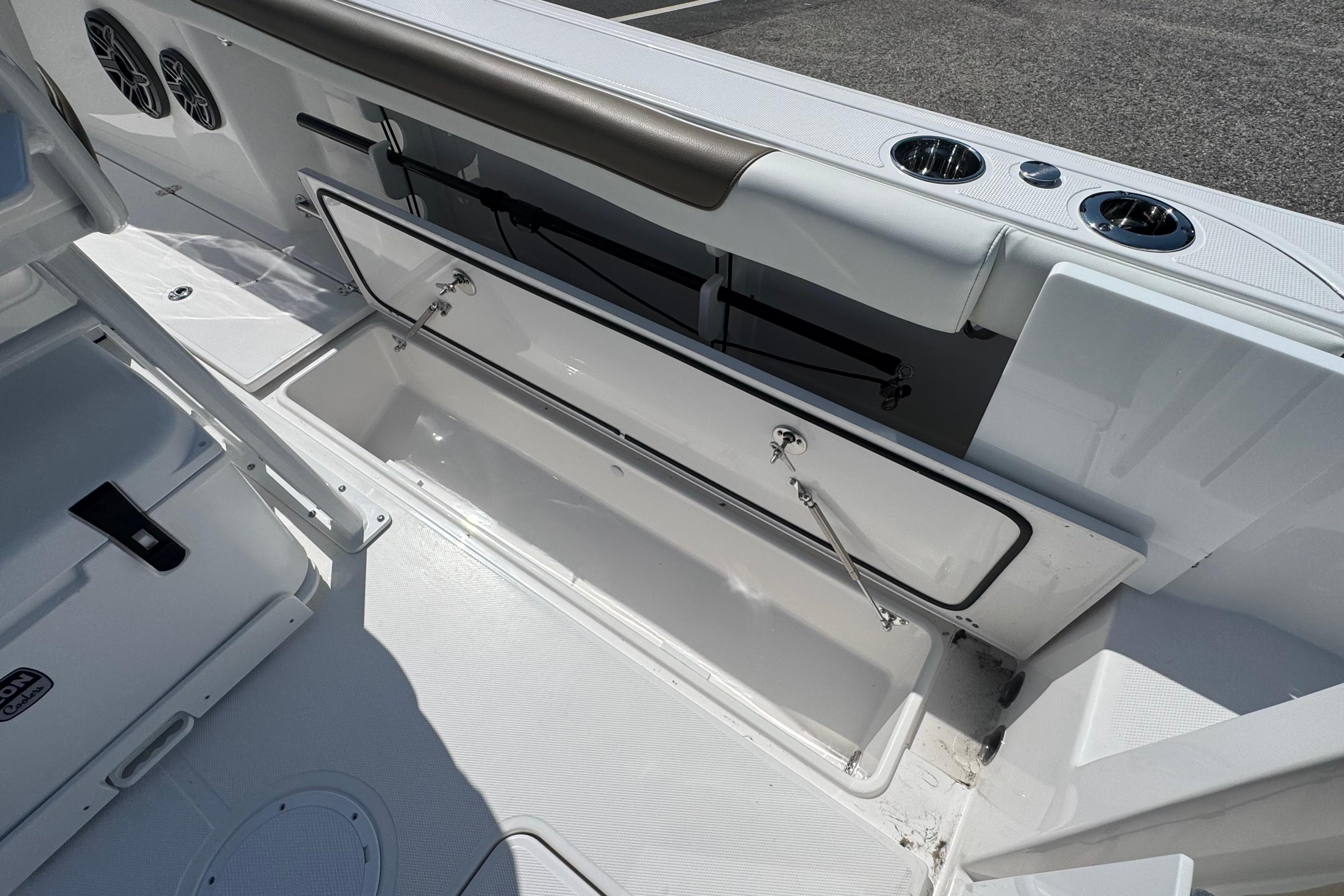 2026 Edgewater 250CC boat interior with open storage compartment and cup holders.