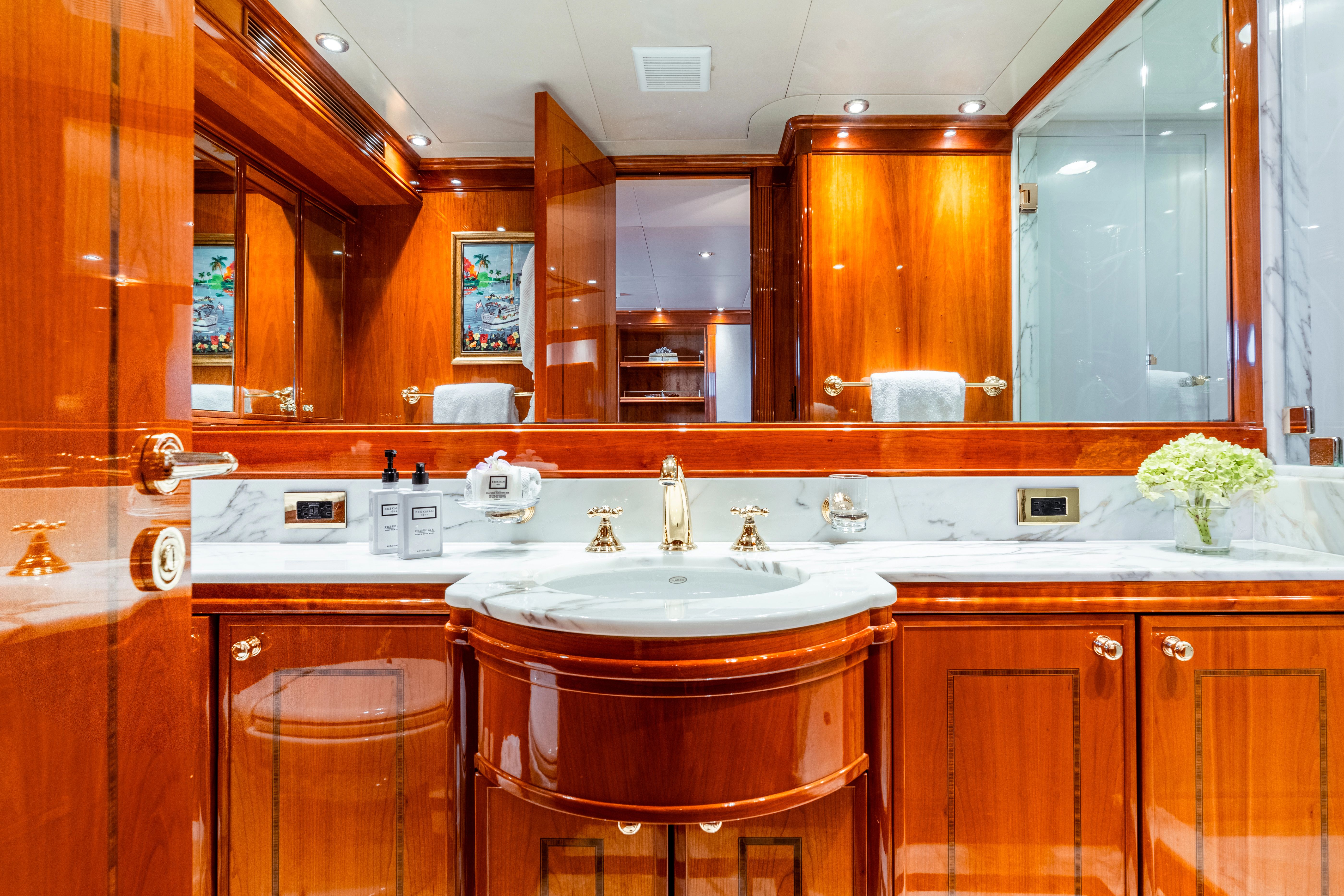 Luxurious bathroom with wood paneling and marble sink on a yacht.