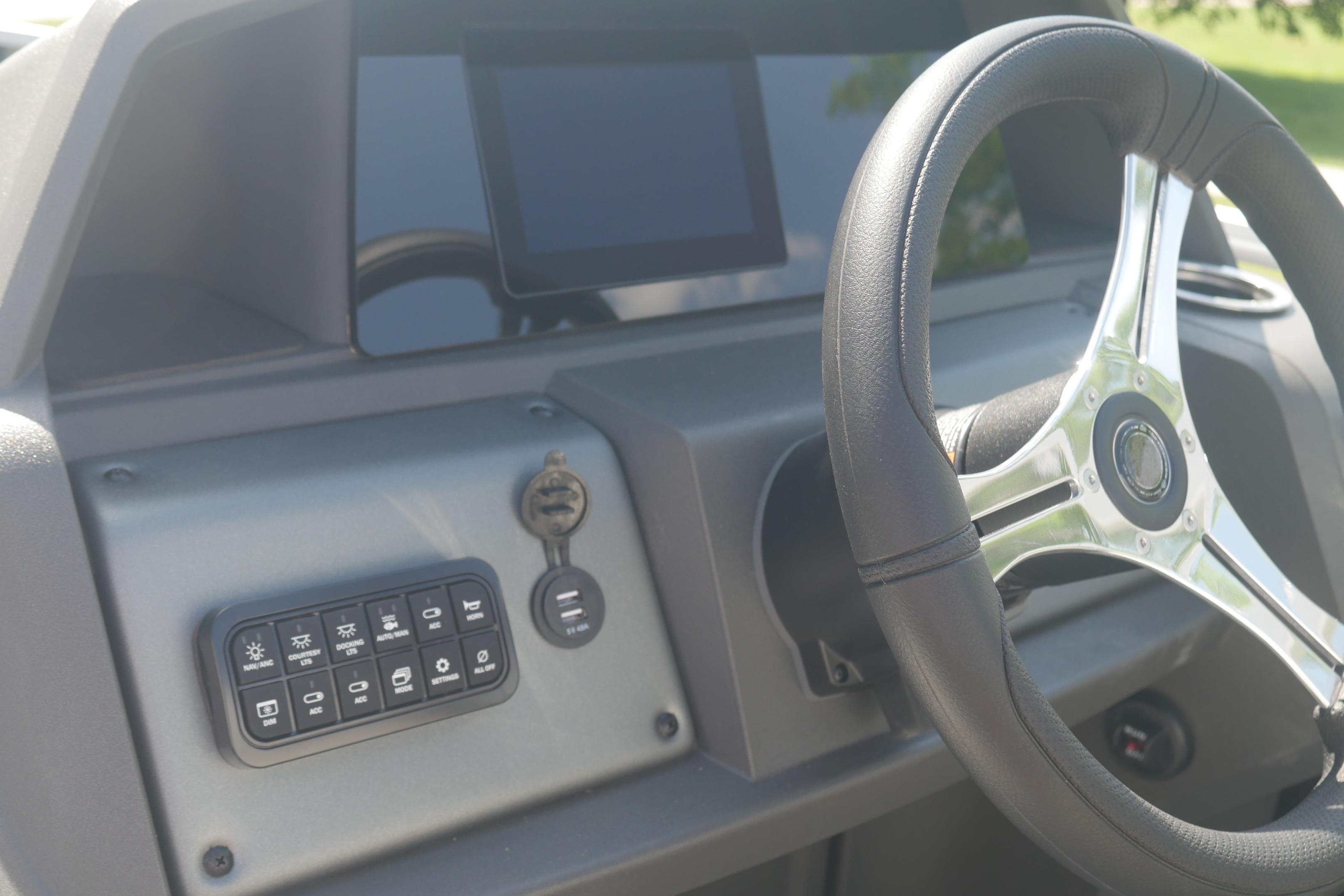Steering console of 2026 Sun Tracker Fishin' Barge 20 DLX with control panel.
