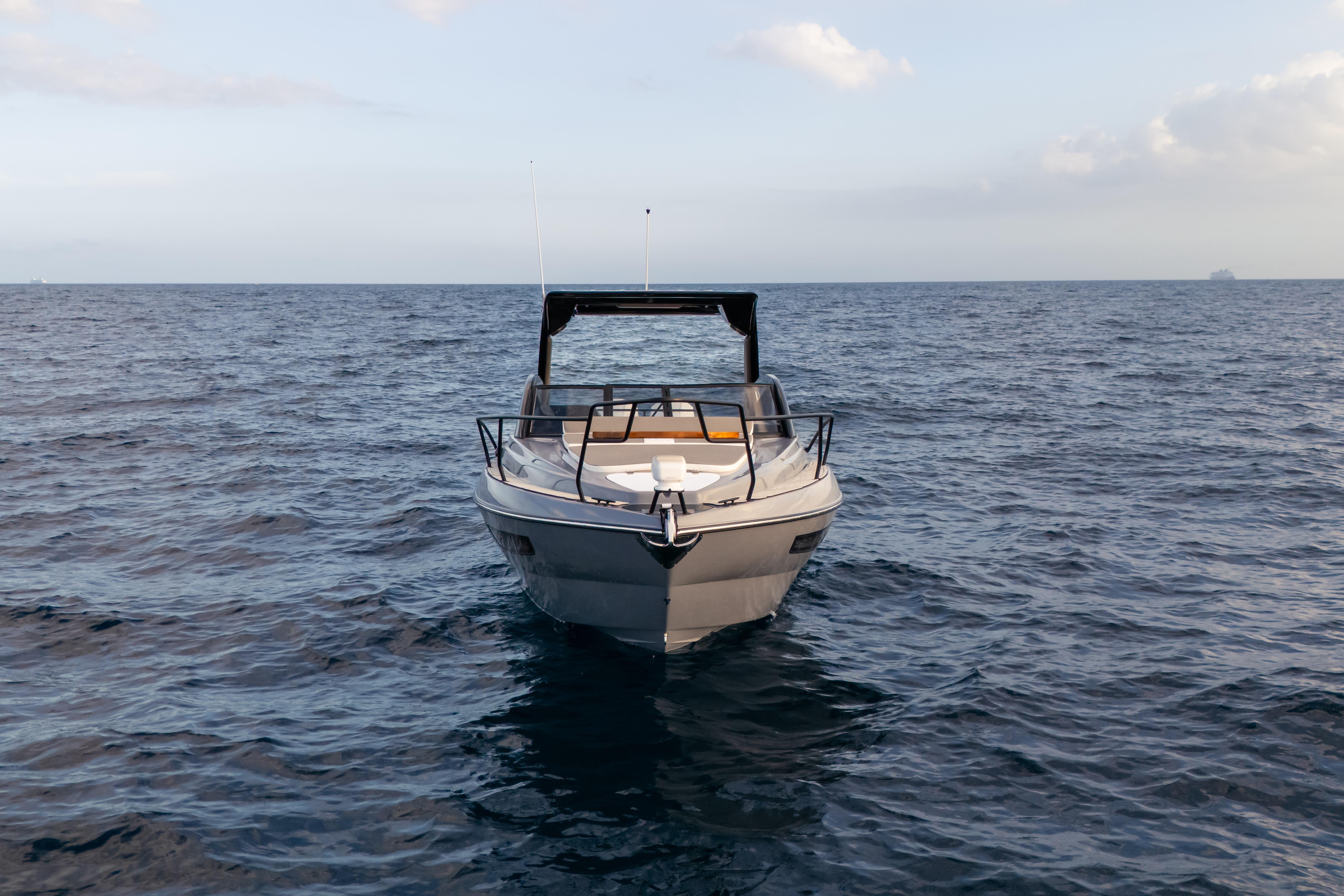 Front view of a 2026 Hanover 305 boat on open water under a clear sky.