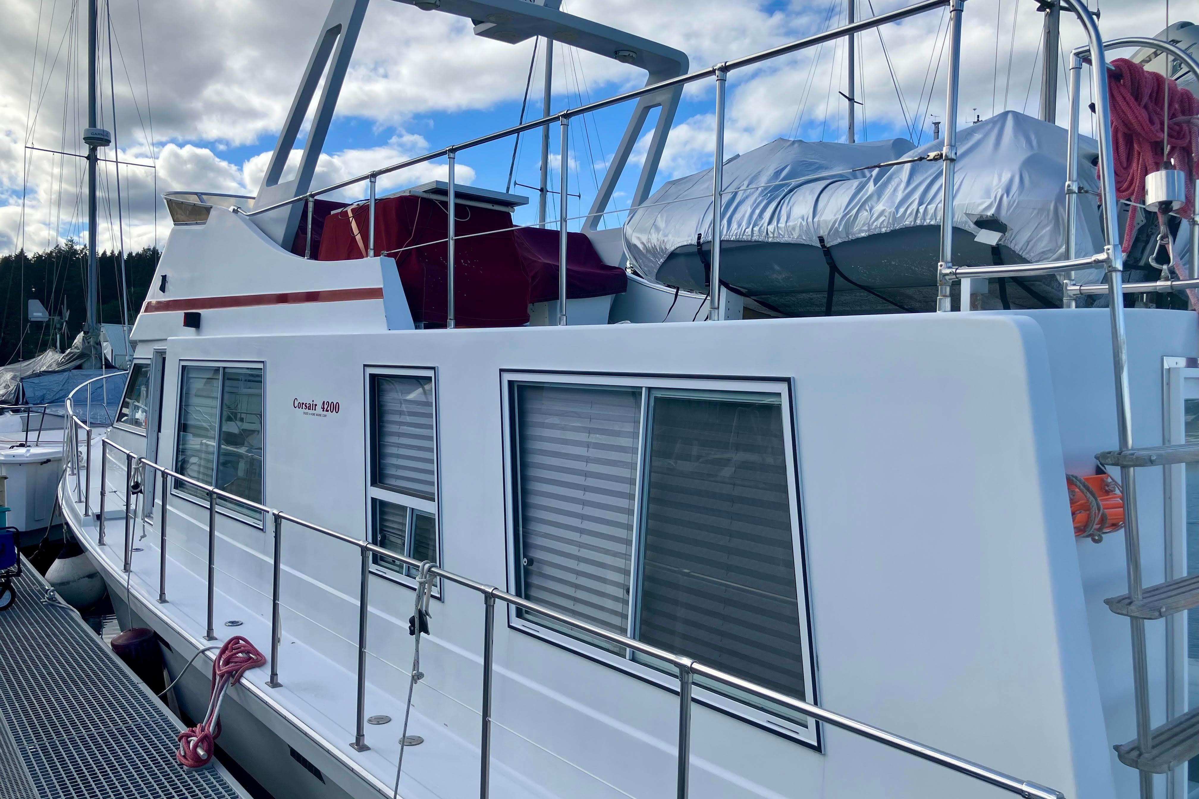 1992 Cruise-A-Home Corsair 4200 boat docked, featuring sleek design and spacious deck.