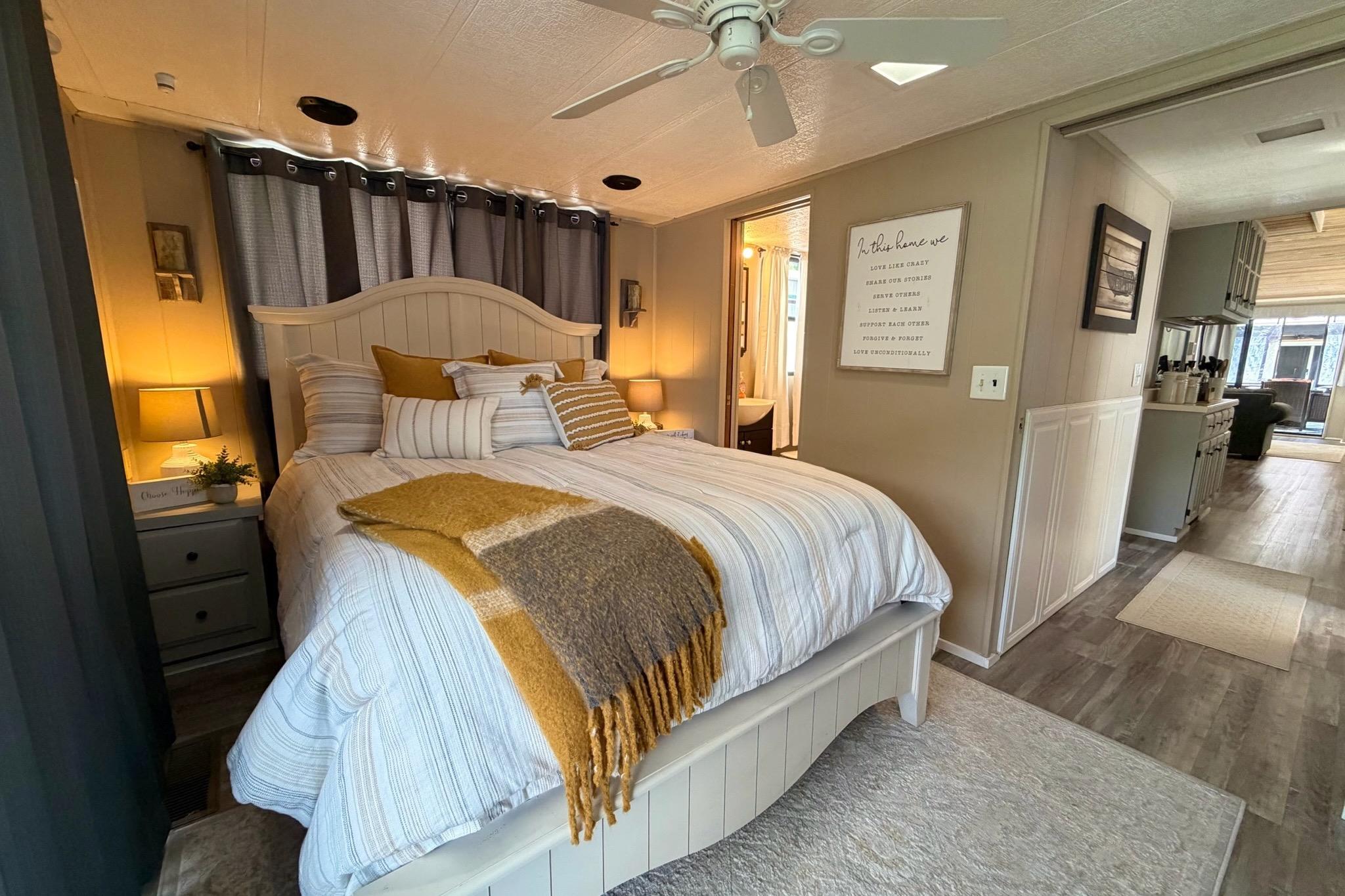 Cozy bedroom in 1988 STARDUST 16x70 houseboat with modern decor and warm lighting.