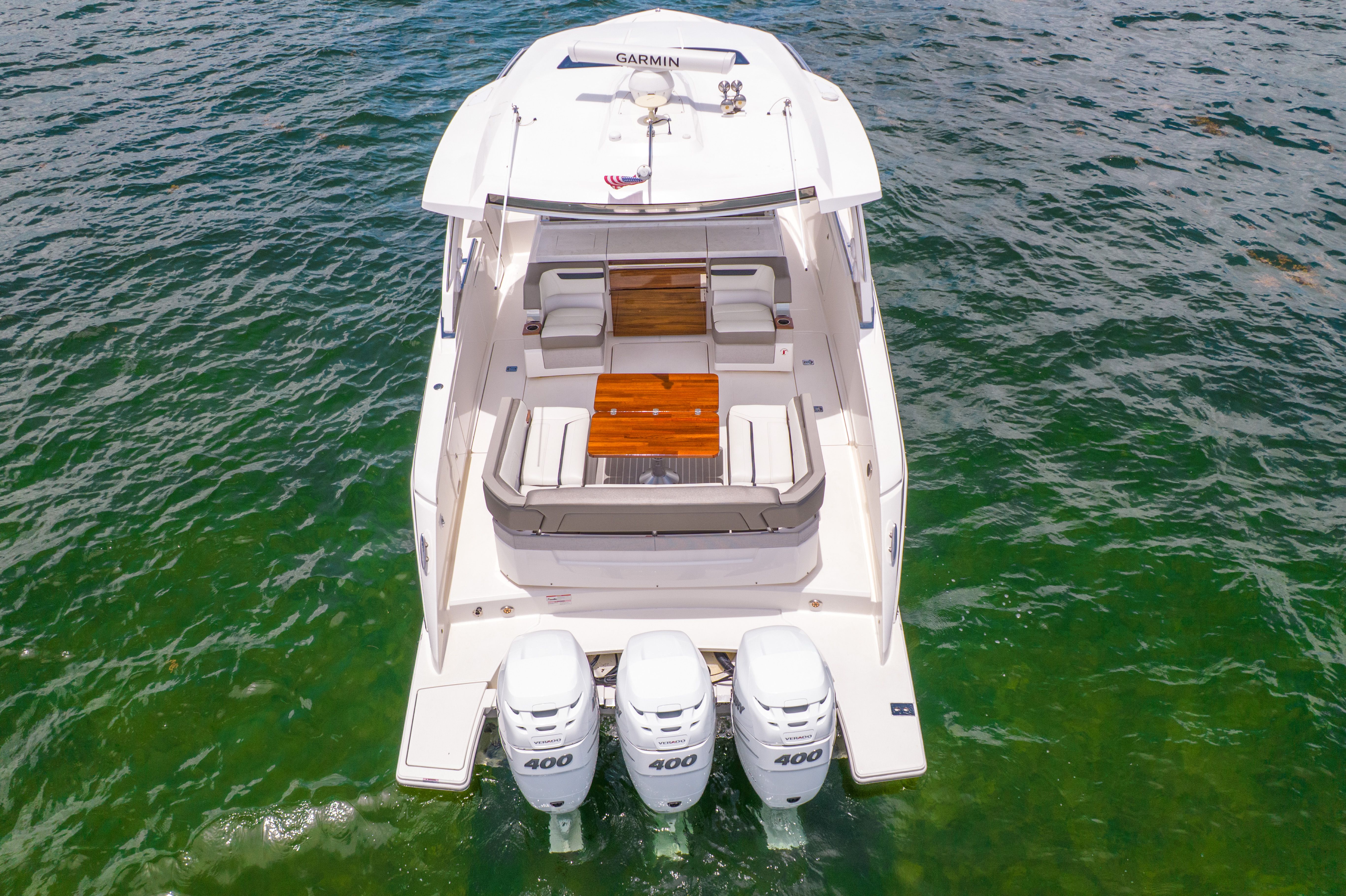The 2023 Tiara Yachts 38 LS is on the water, featuring three outboard engines and a spacious deck.