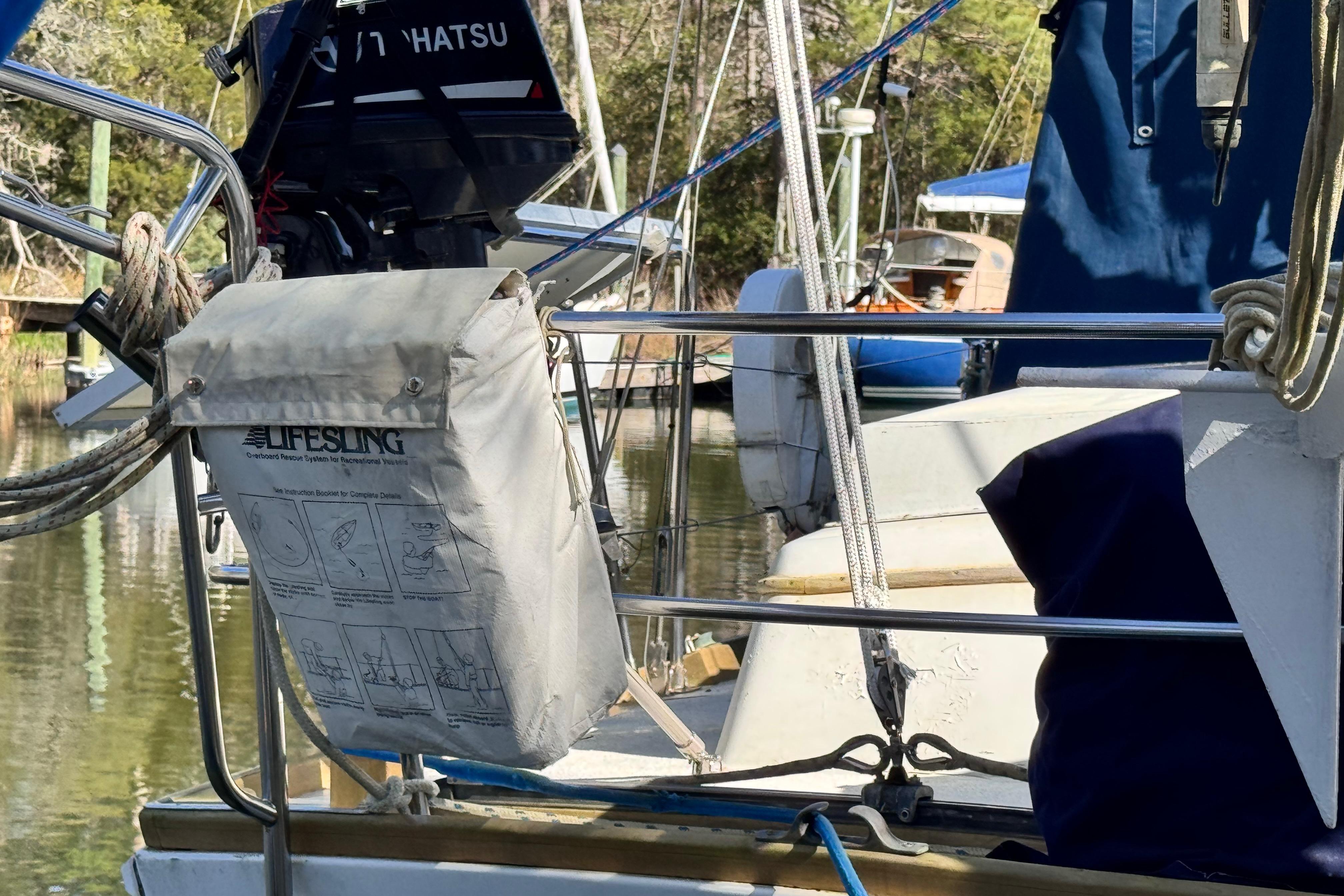 1980 Dickerson Center Cockpit Ketch with Lifesling and Tohatsu motor in marina setting.