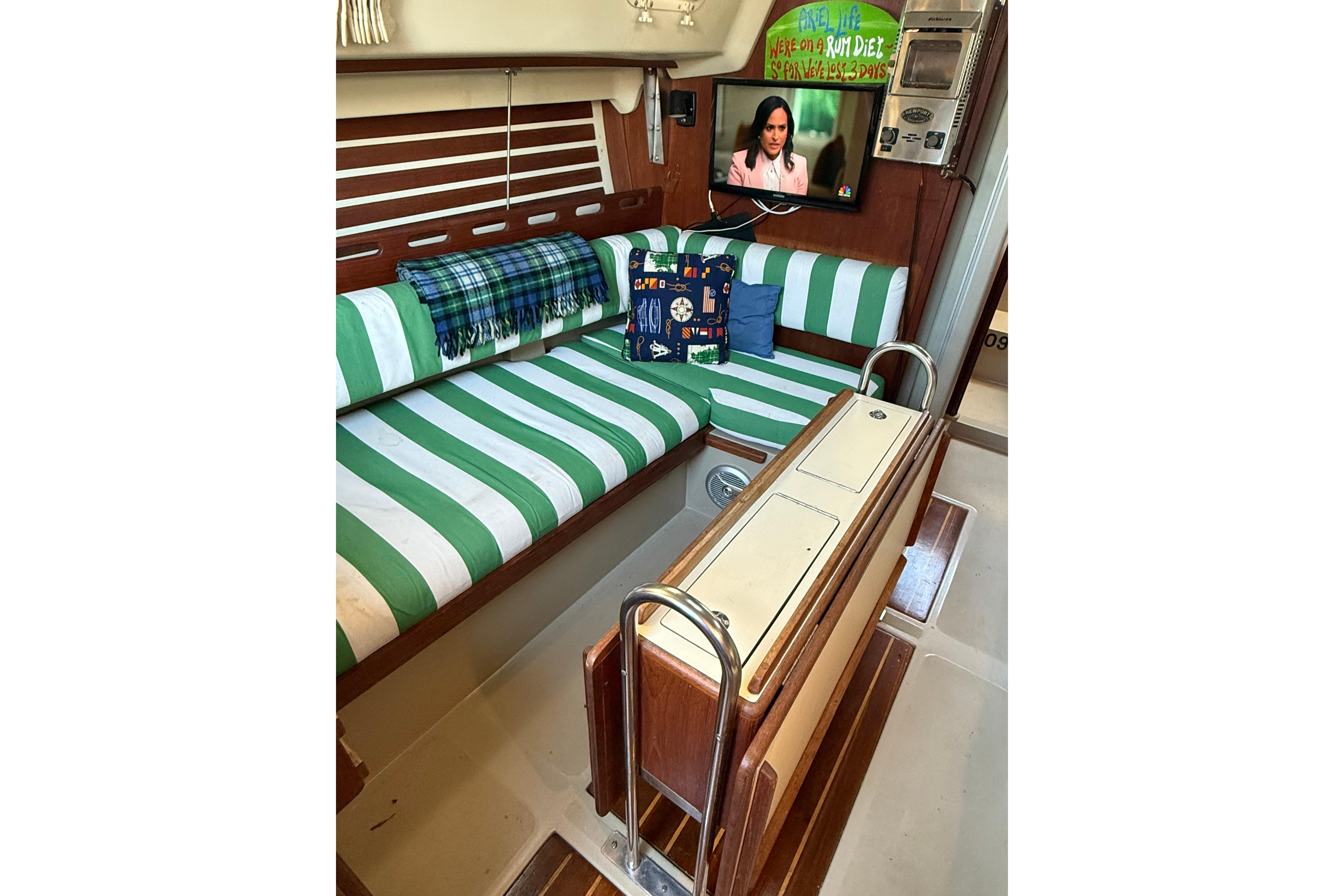 Interior of 1983 O'Day 34 sailboat with striped seating, TV, and nautical decor.