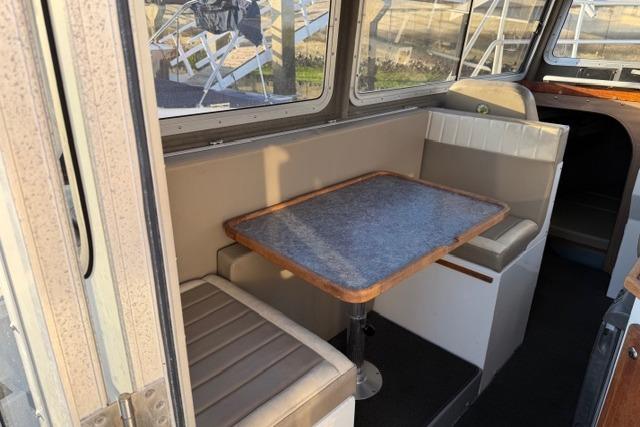 2007 ACB Sportfisher boat interior with dining area and cushioned seating.