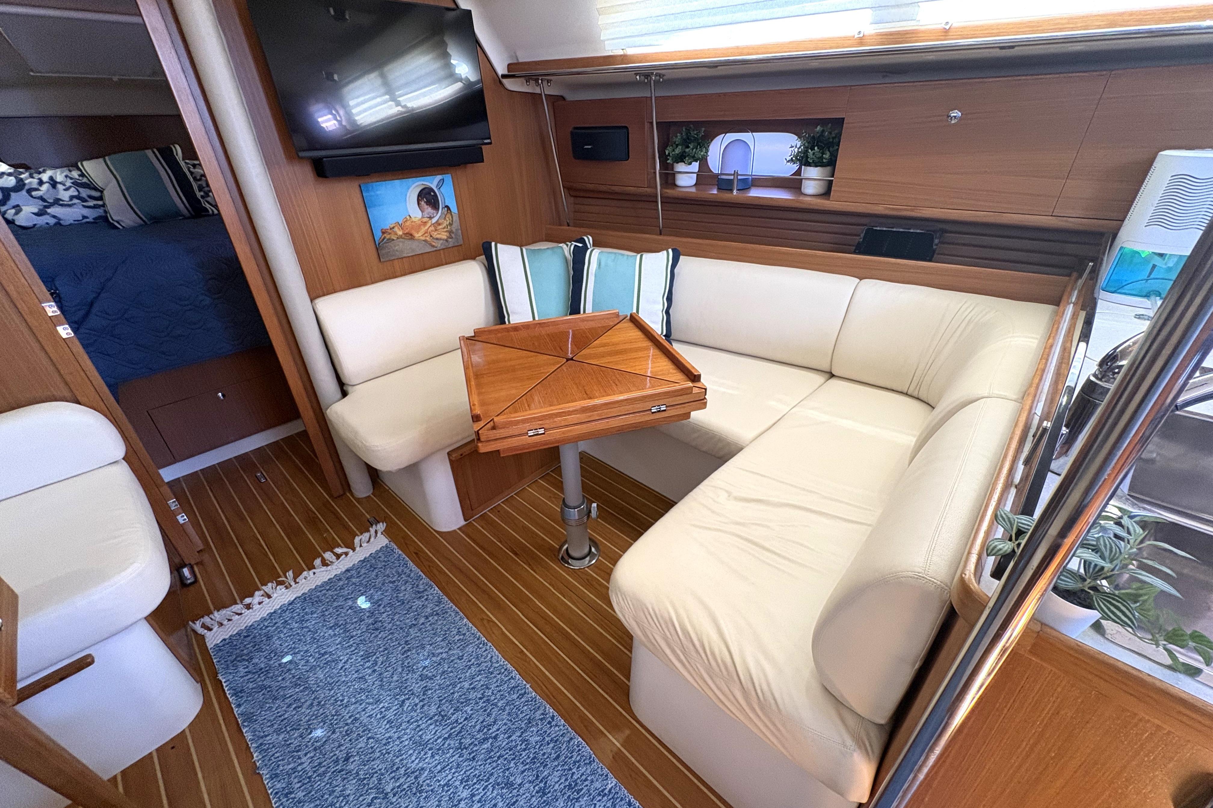 Interior of 2011 Catalina 355 yacht with cozy seating and elegant wooden table.