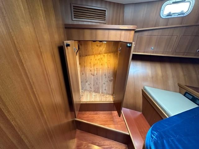 Wooden interior of 2025 Bracewell 41 boat with open storage compartment.